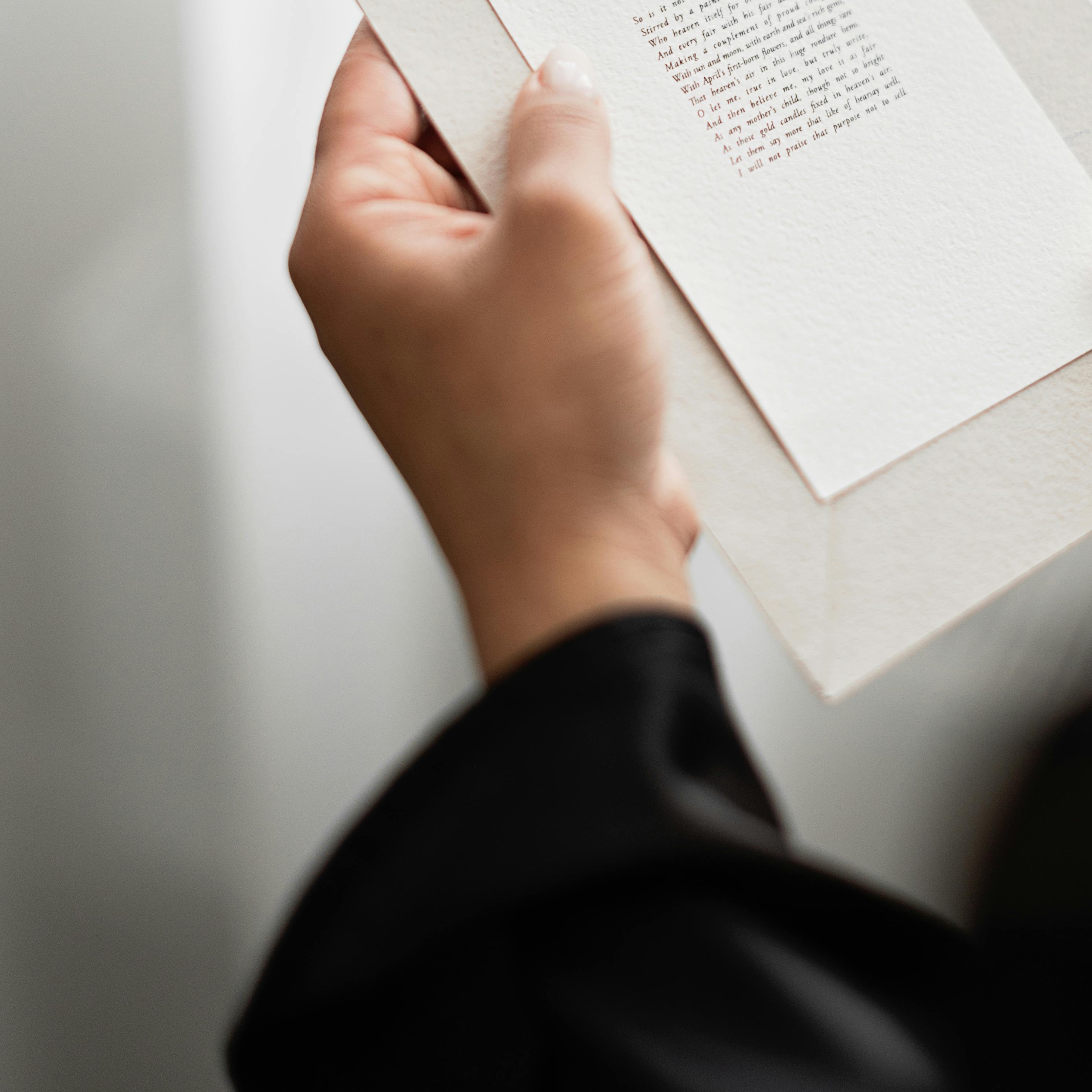 Eine Hand, die eine gedruckte Einladung hält | Quelle: Pexels