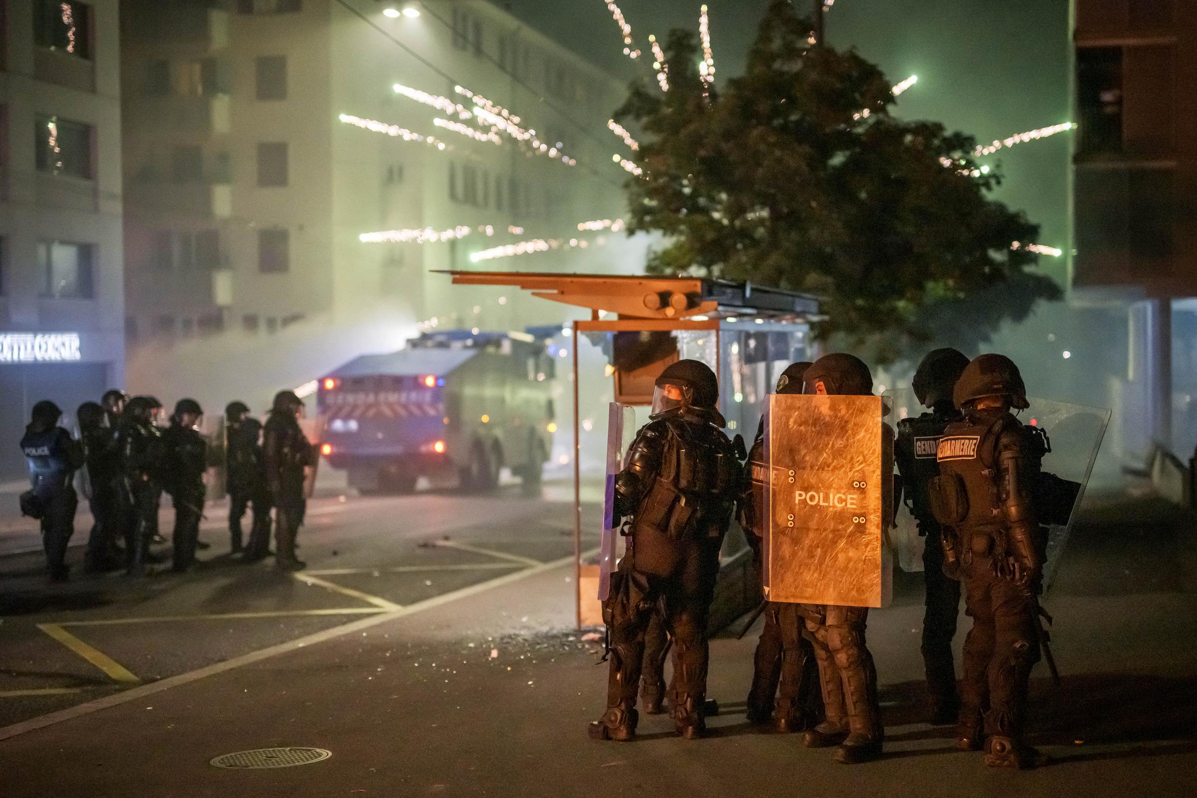 Polizisten in Kampfausrüstung nehmen am 25. August 2025 in einer Straße in Lausanne ihre Position ein, während es nach dem Tod eines Teenagers, der mit einem gestohlenen Motorroller vor der örtlichen Polizei fliehen wollte, bereits die zweite Nacht in Folge zu Ausschreitungen kommt. | Quelle: Getty Images