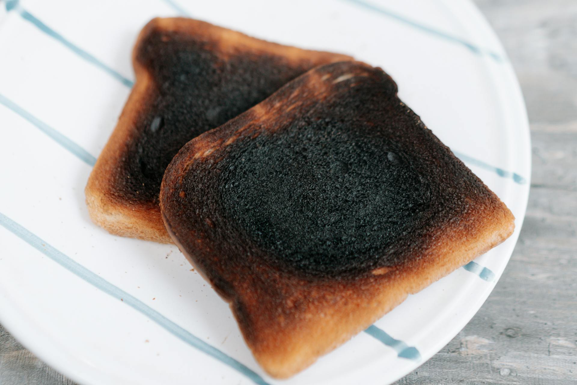 Zwei Scheiben verbrannter Toast auf einem Keramikteller | Quelle: Pexels