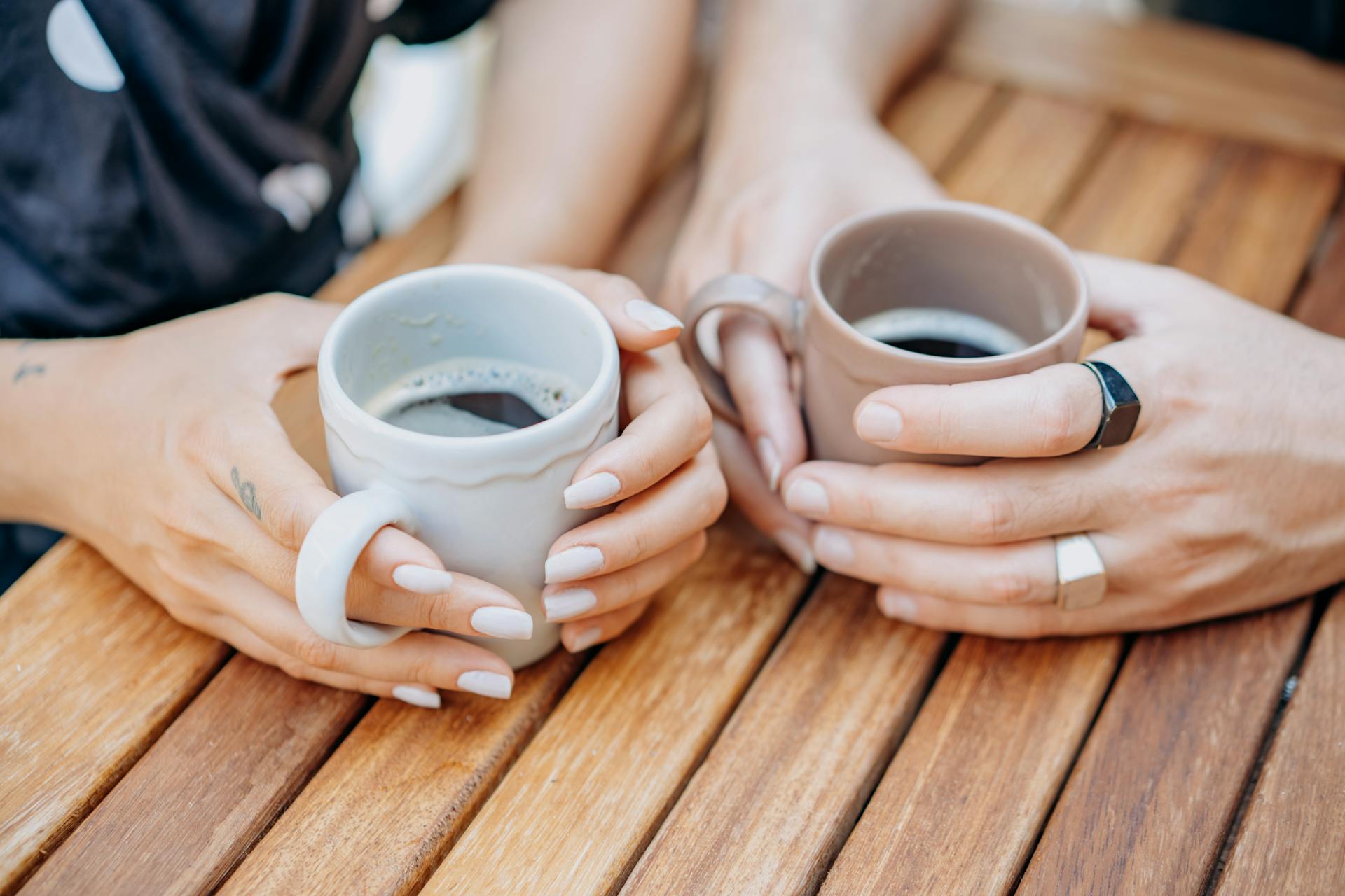 Zwei Frauen mit Kaffeetassen in der Hand | Quelle: Pexels