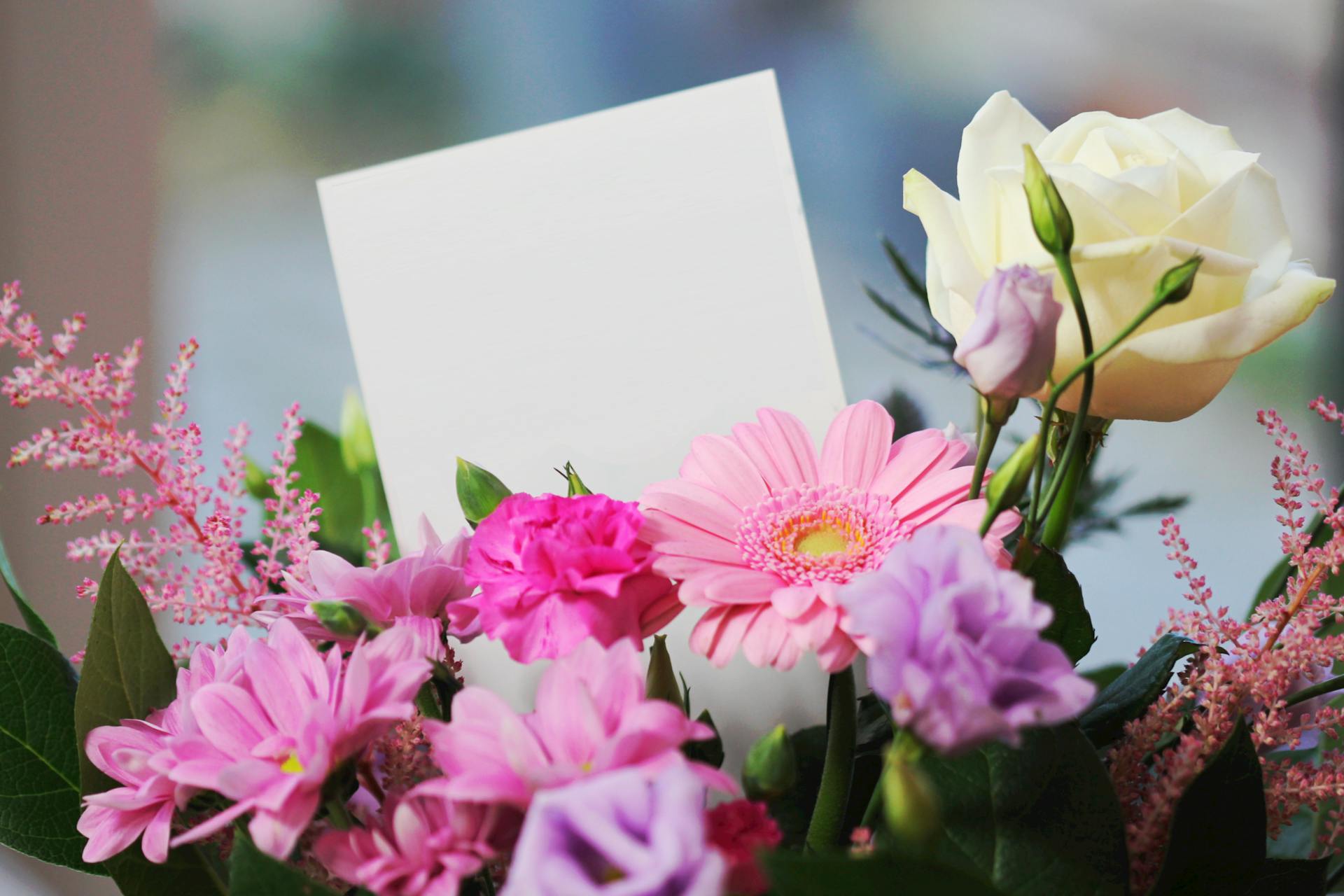 Eine Karte, die aus einem Blumenstrauß herausragt | Quelle: Pexels