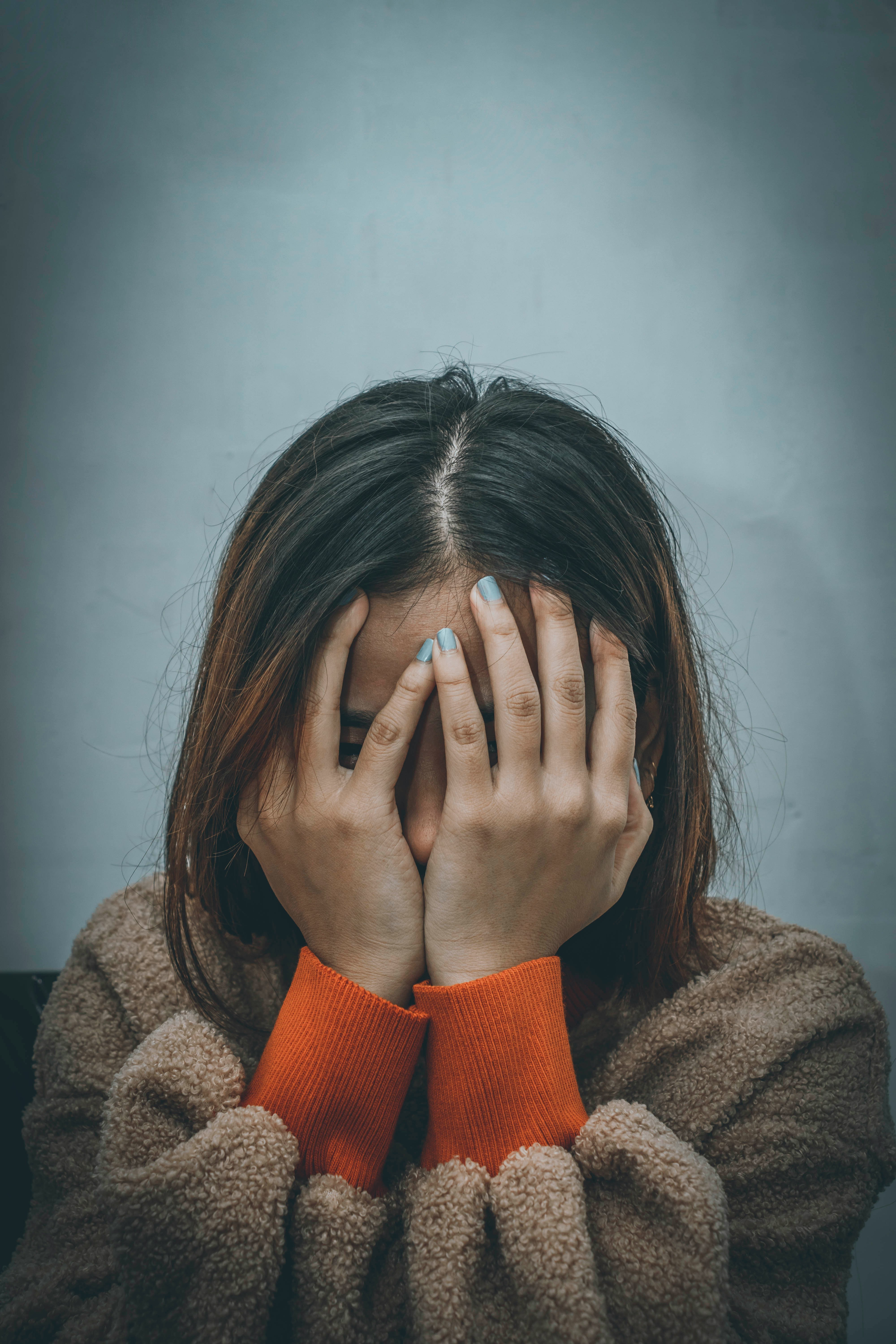 Eine junge Frau, die ihr Gesicht hält | Quelle: Unsplash