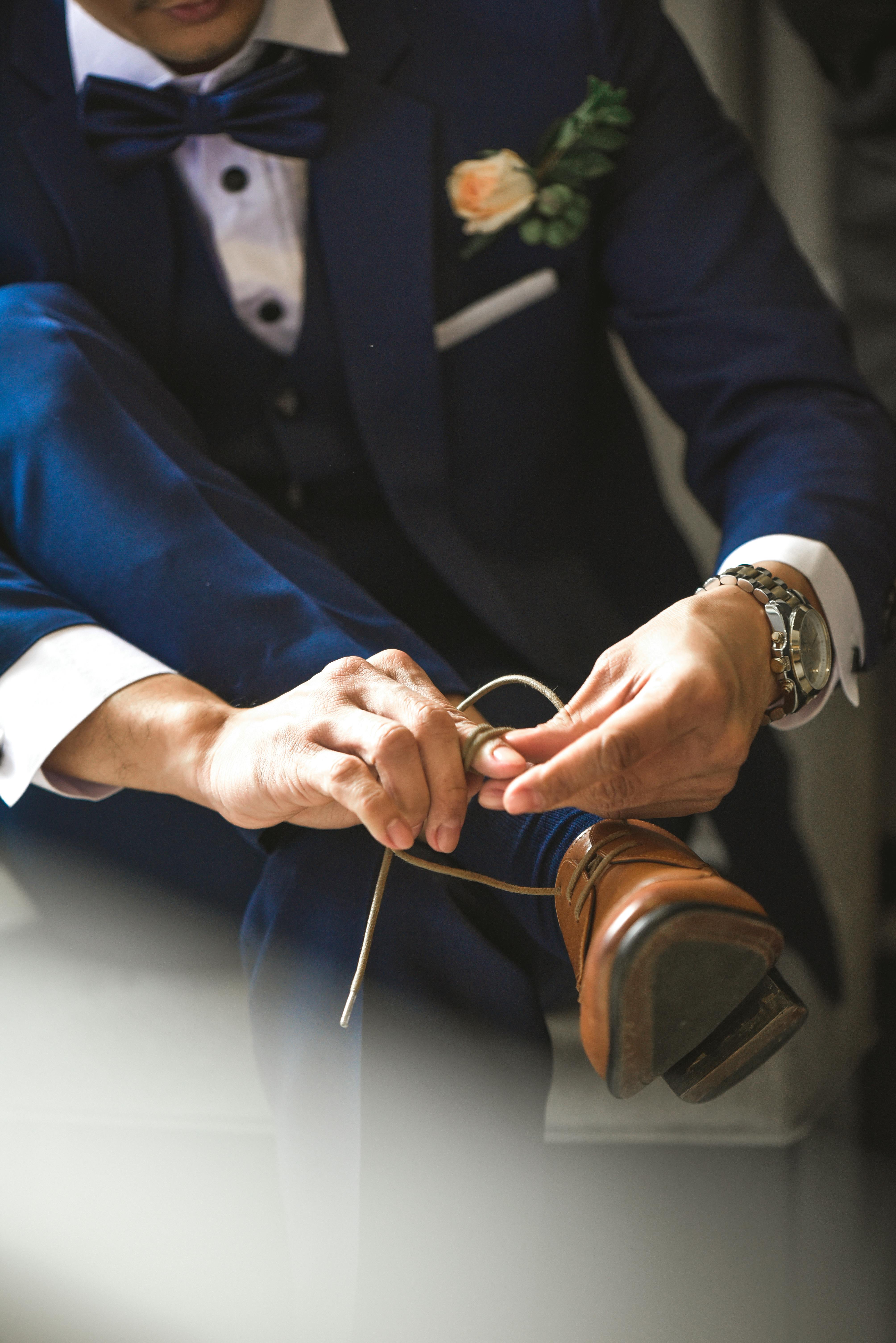 Pan młody wiążący buty | Źródło: Pexels