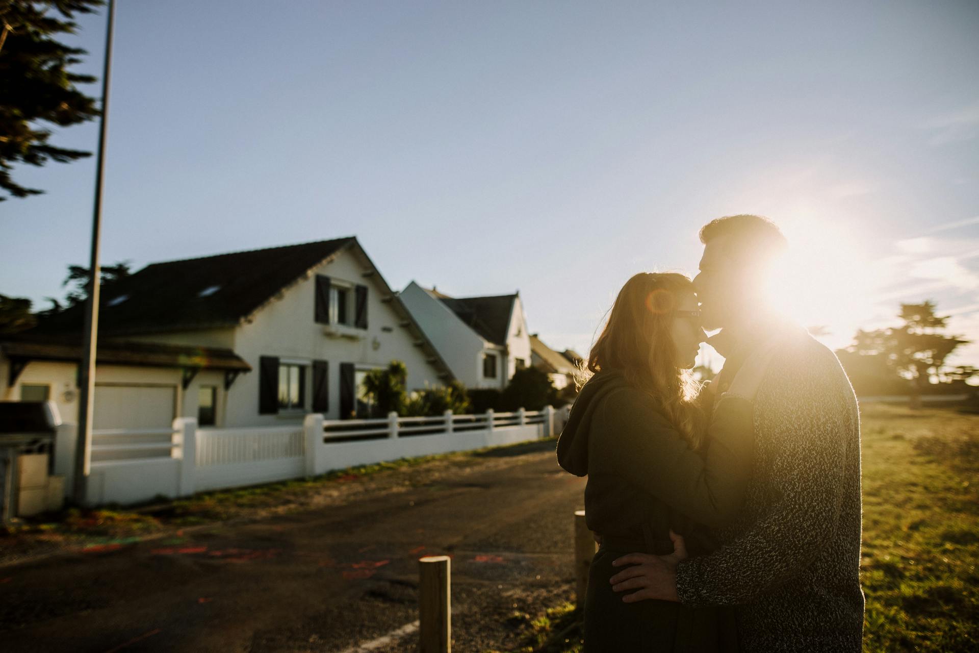 Ein Mann küsst eine Frau vor einem Haus auf die Stirn | Quelle: Pexels