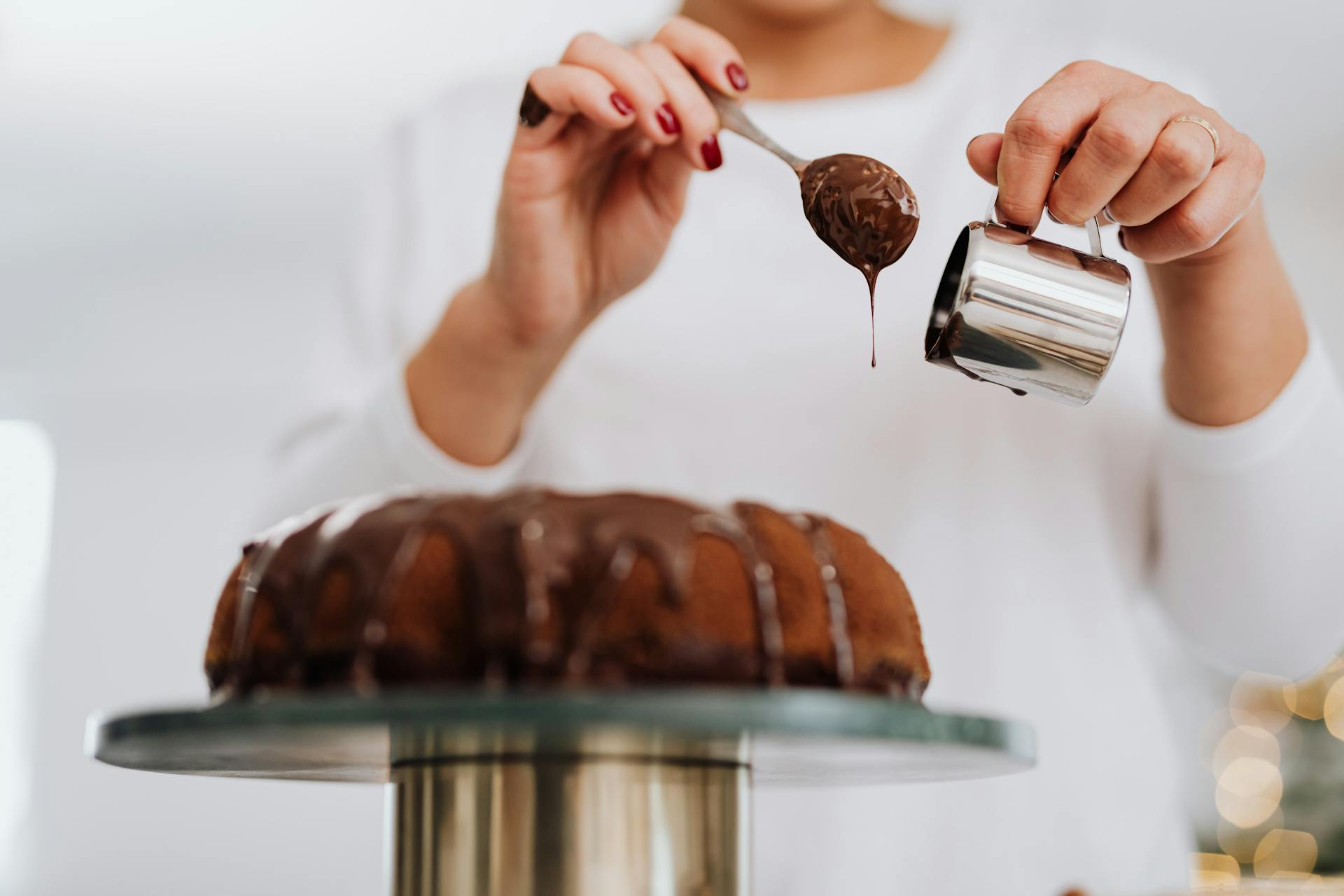 Eine Frau dekoriert einen Kuchen mit Schokolade | Quelle: Pexels
