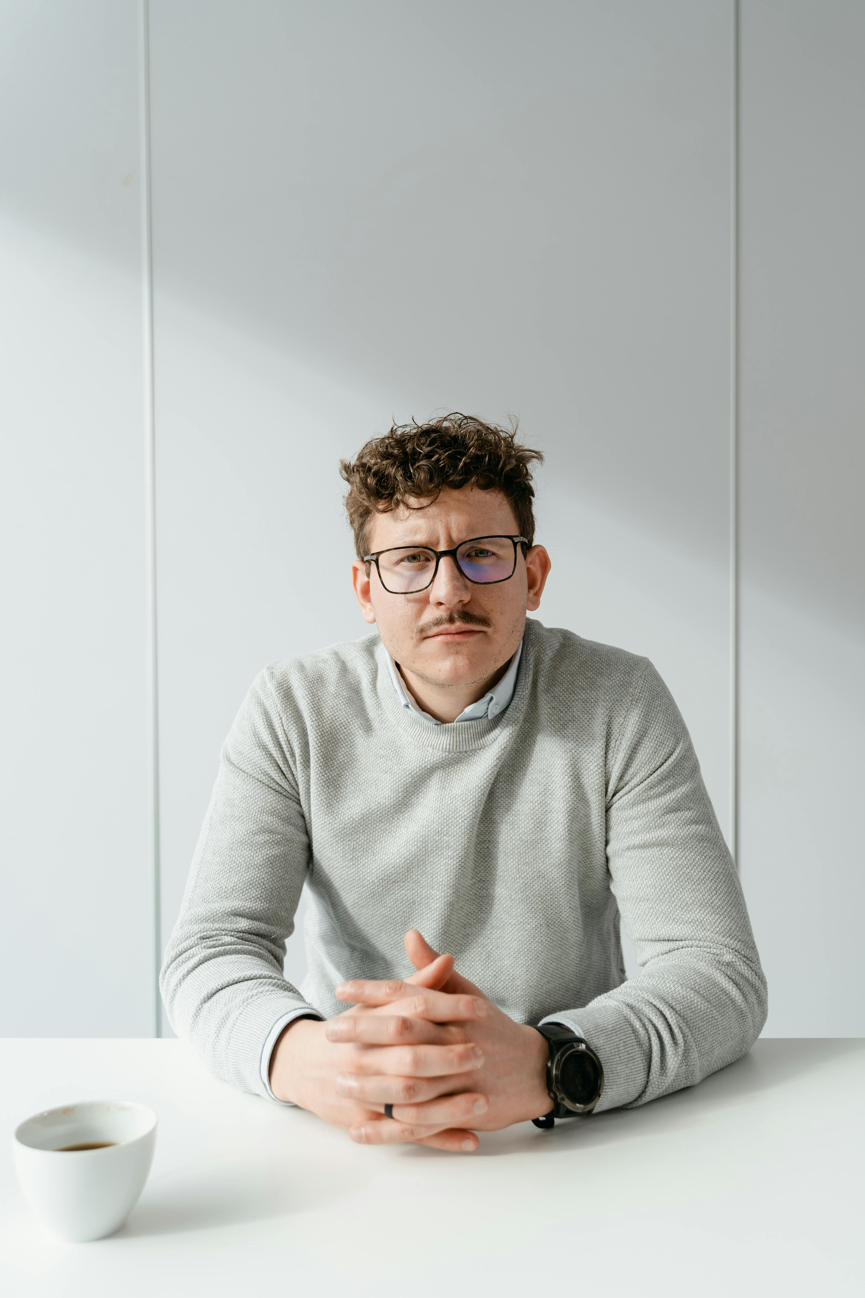 Ein ernster Mann sitzt an einem Tisch | Quelle: Pexels