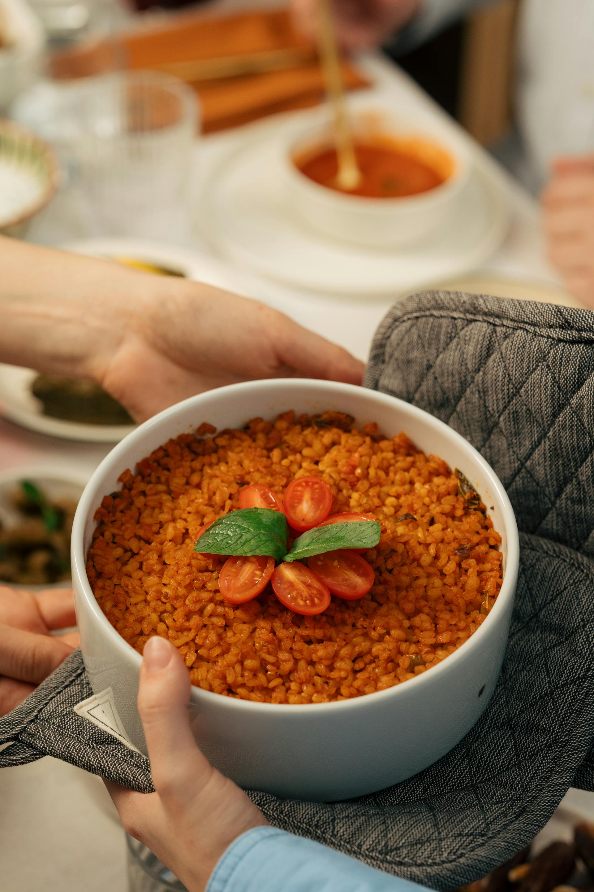 Zwei Hände halten eine Schüssel mit Tomatenpilaw | Quelle: Pexels