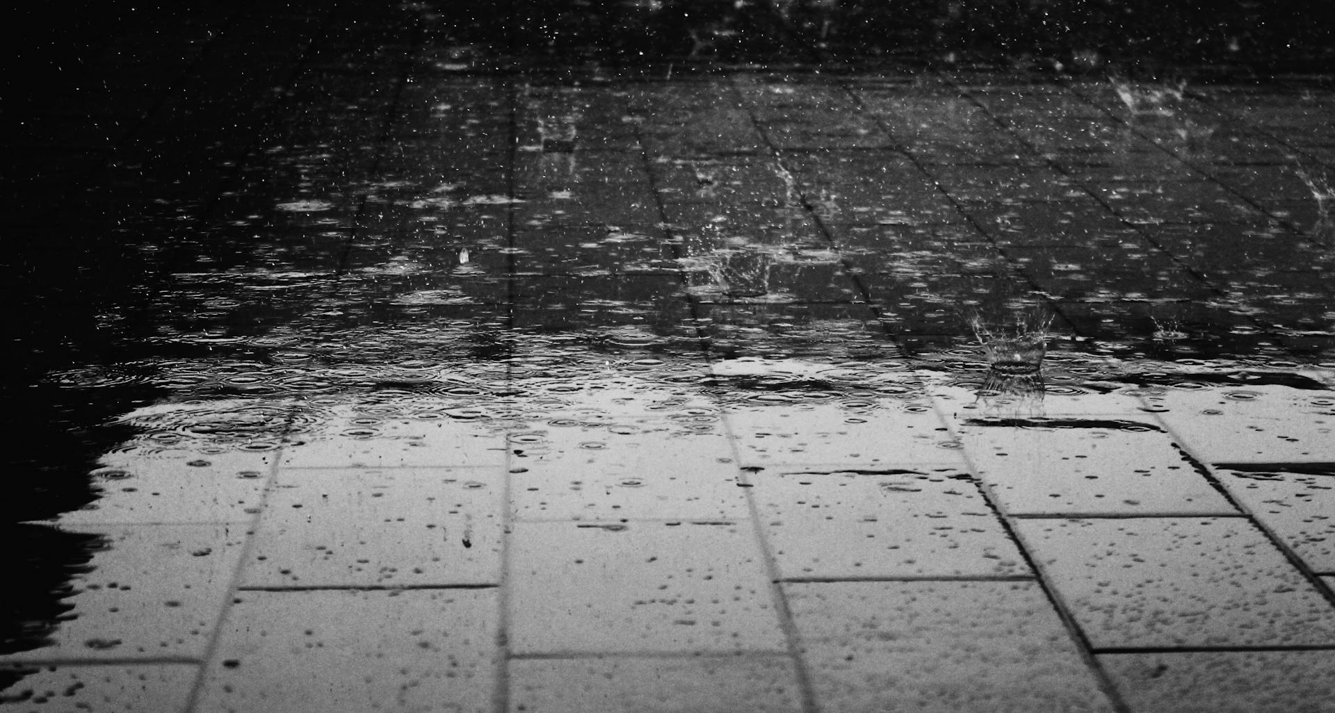 Regentropfen, die auf einen nassen Bürgersteig fallen | Quelle: Pexels