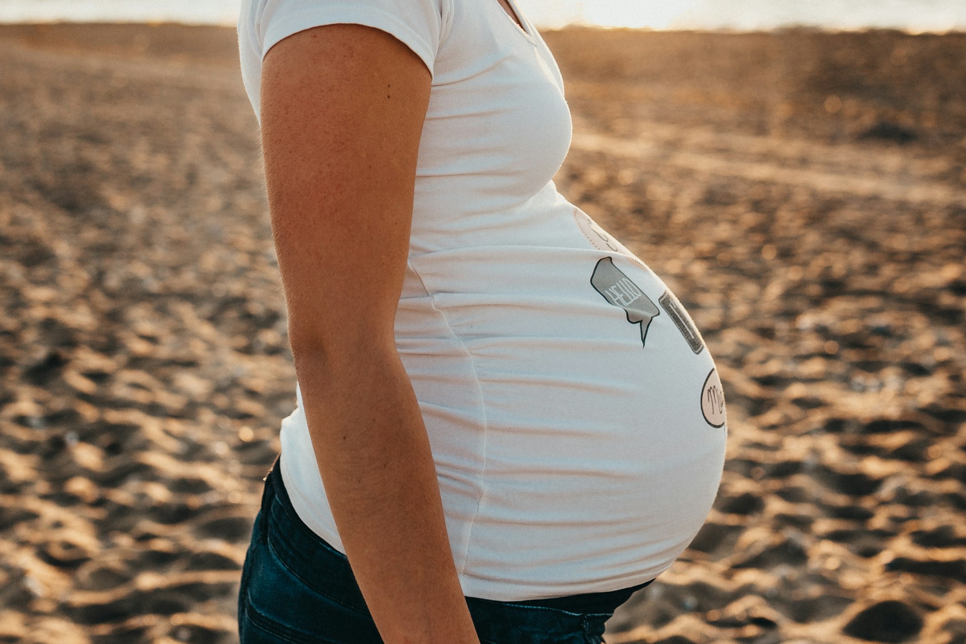 Eine schwangere Frau steht am Strand | Quelle: Unsplash