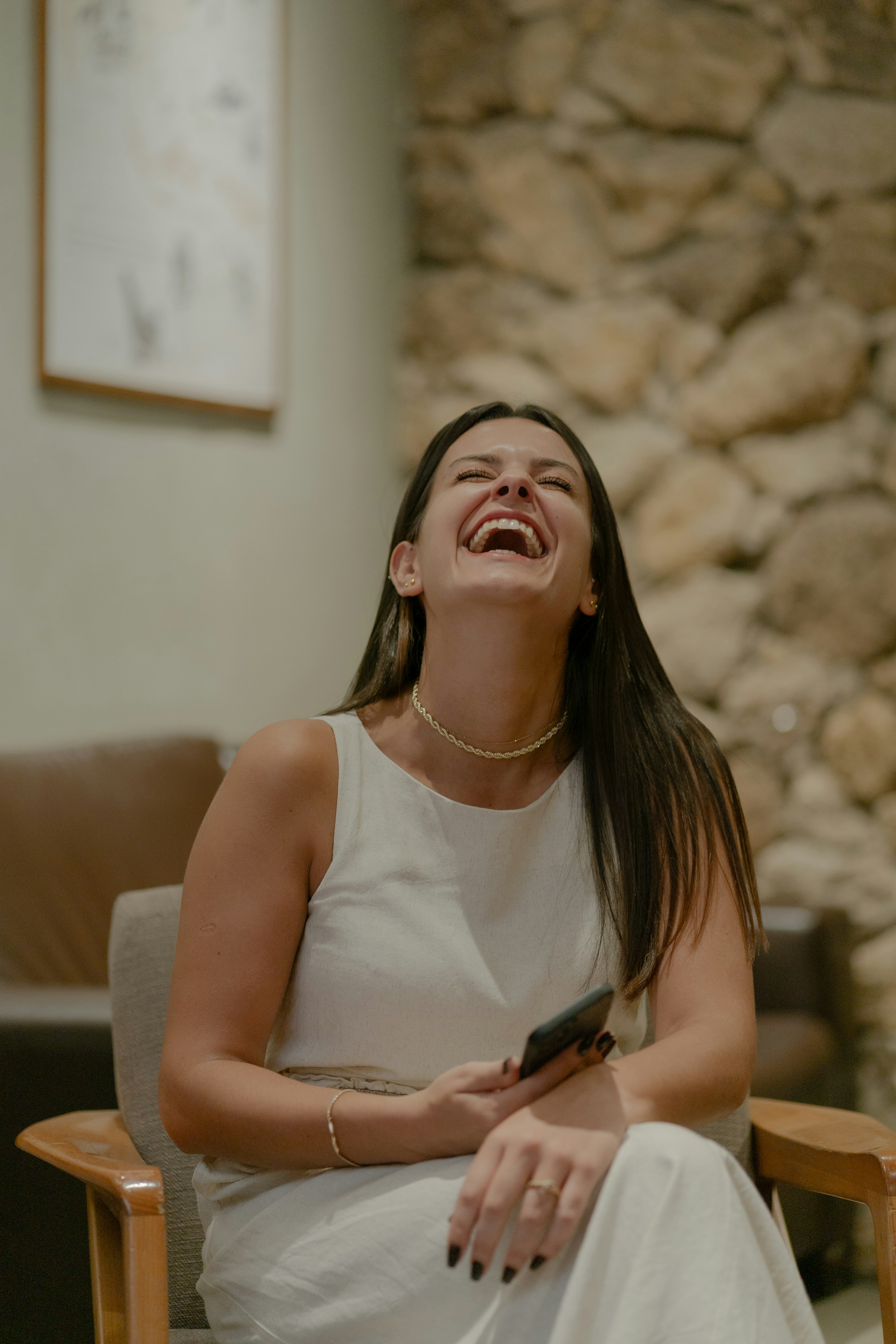 Eine Frau lacht, während sie ihr Telefon hält | Quelle: Unsplash