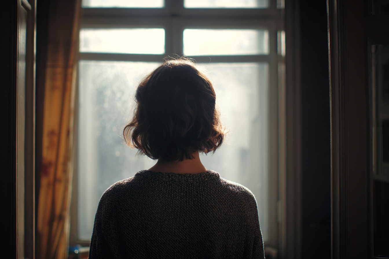 Eine Frau, die an einem Fenster steht | Quelle: Midjourney