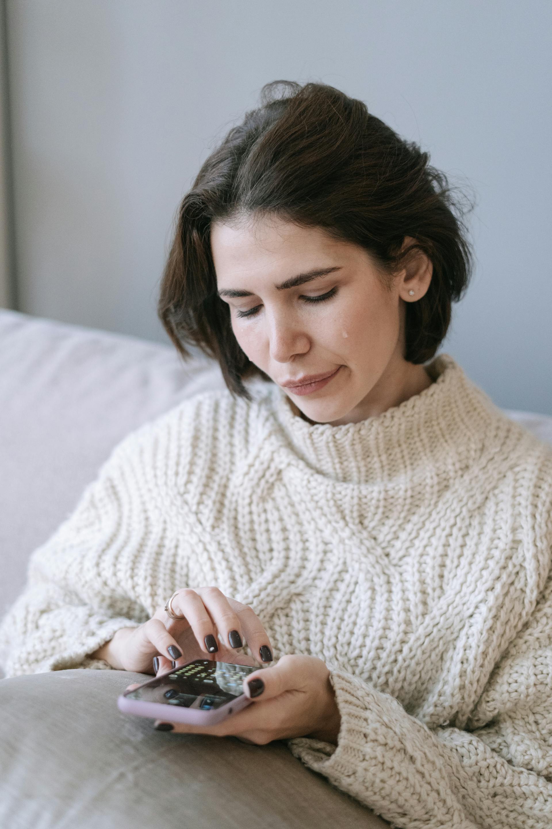 Eine weinende Frau, die ein Handy hält | Quelle: Pexels