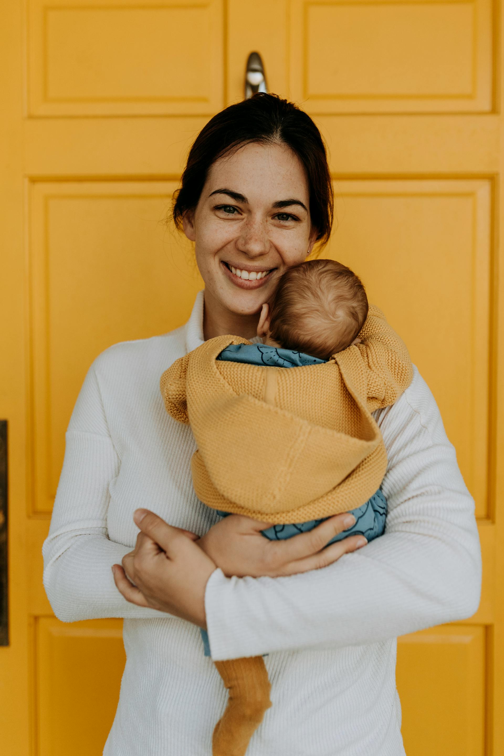 Eine glückliche Frau, die ein Baby hält | Quelle: Pexels