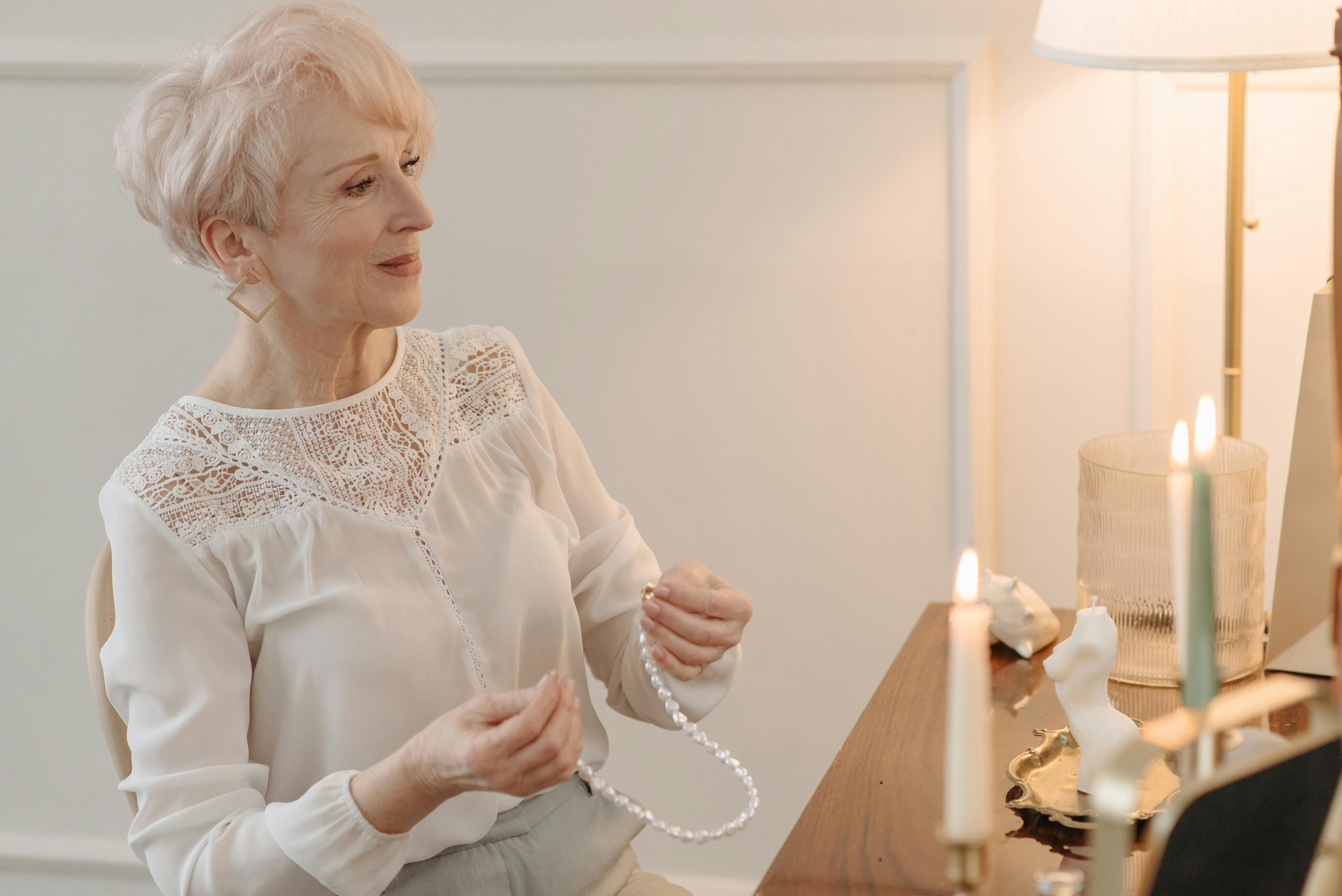 Eine alte Frau, die an ihrer Kommode sitzt | Quelle: Pexels