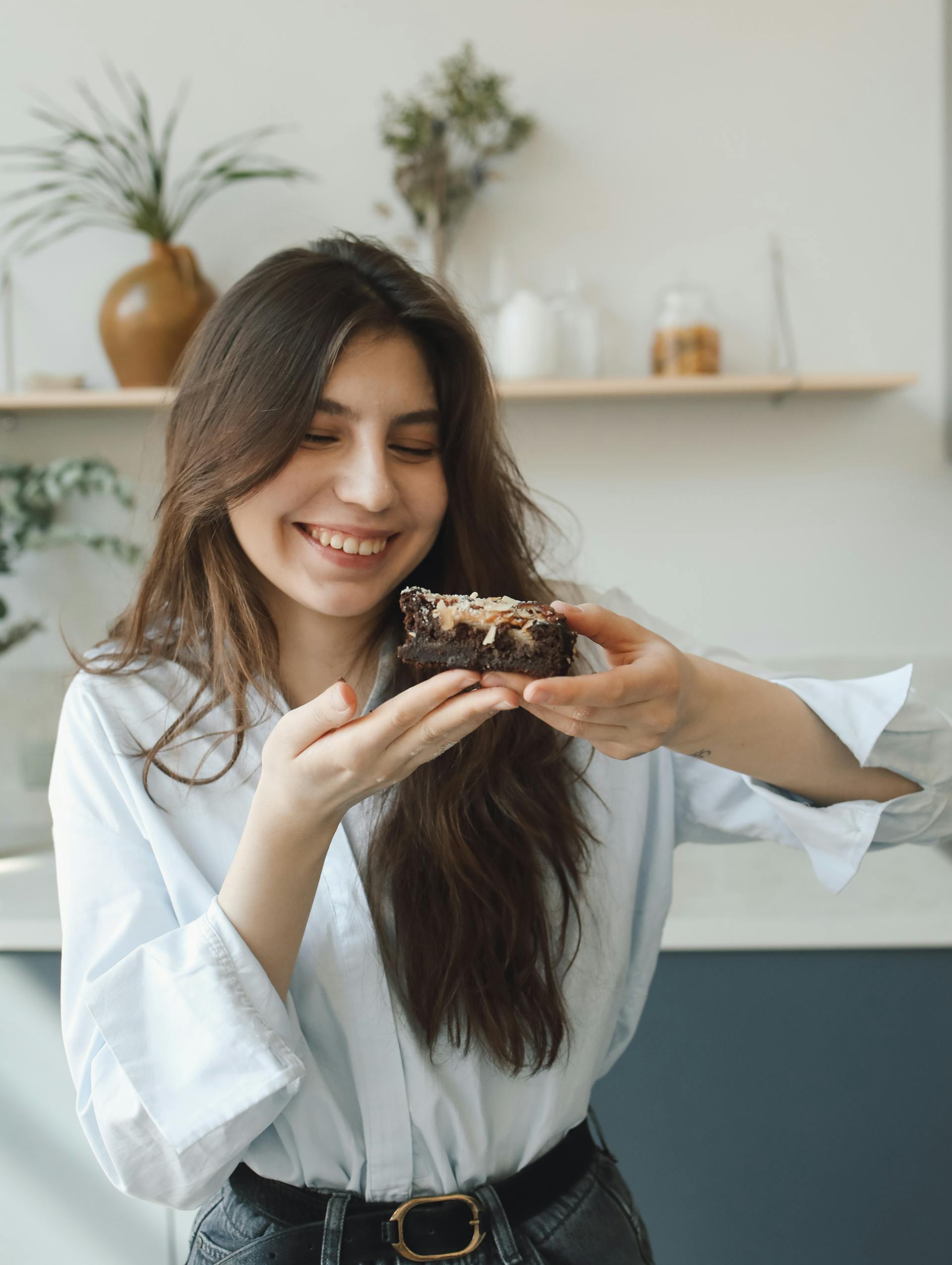 Eine Frau hält ein Stück Kuchen in der Hand | Quelle: Pexels