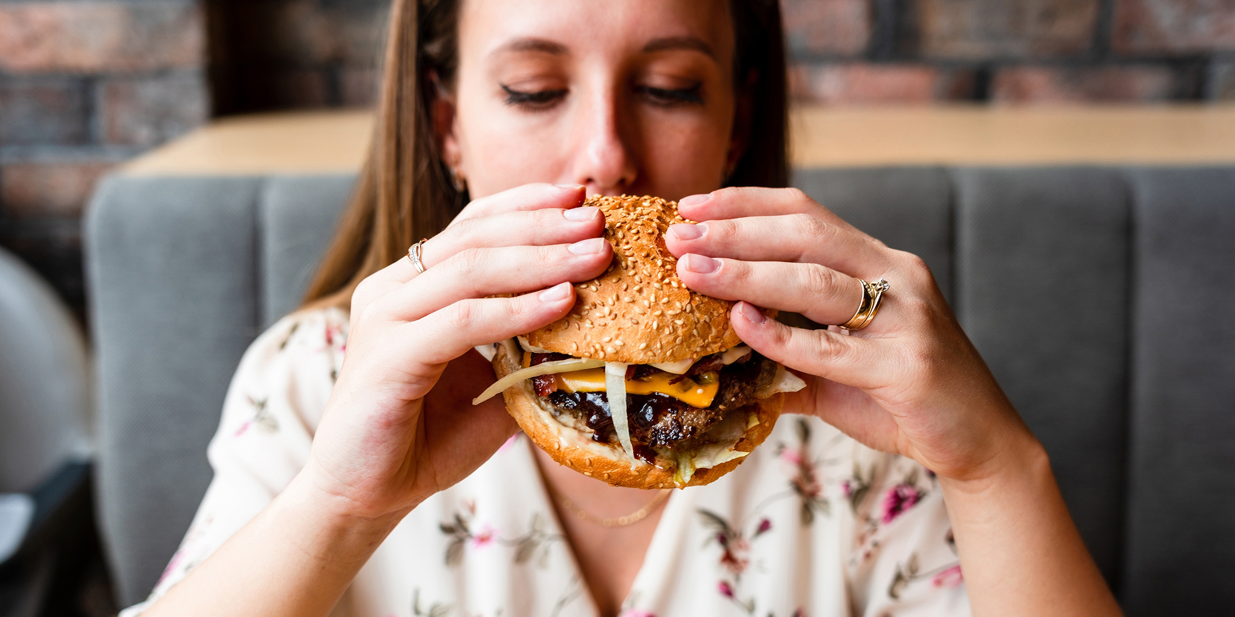 Eine Frau beim Essen eines Burgers | Quelle: Shutterstock