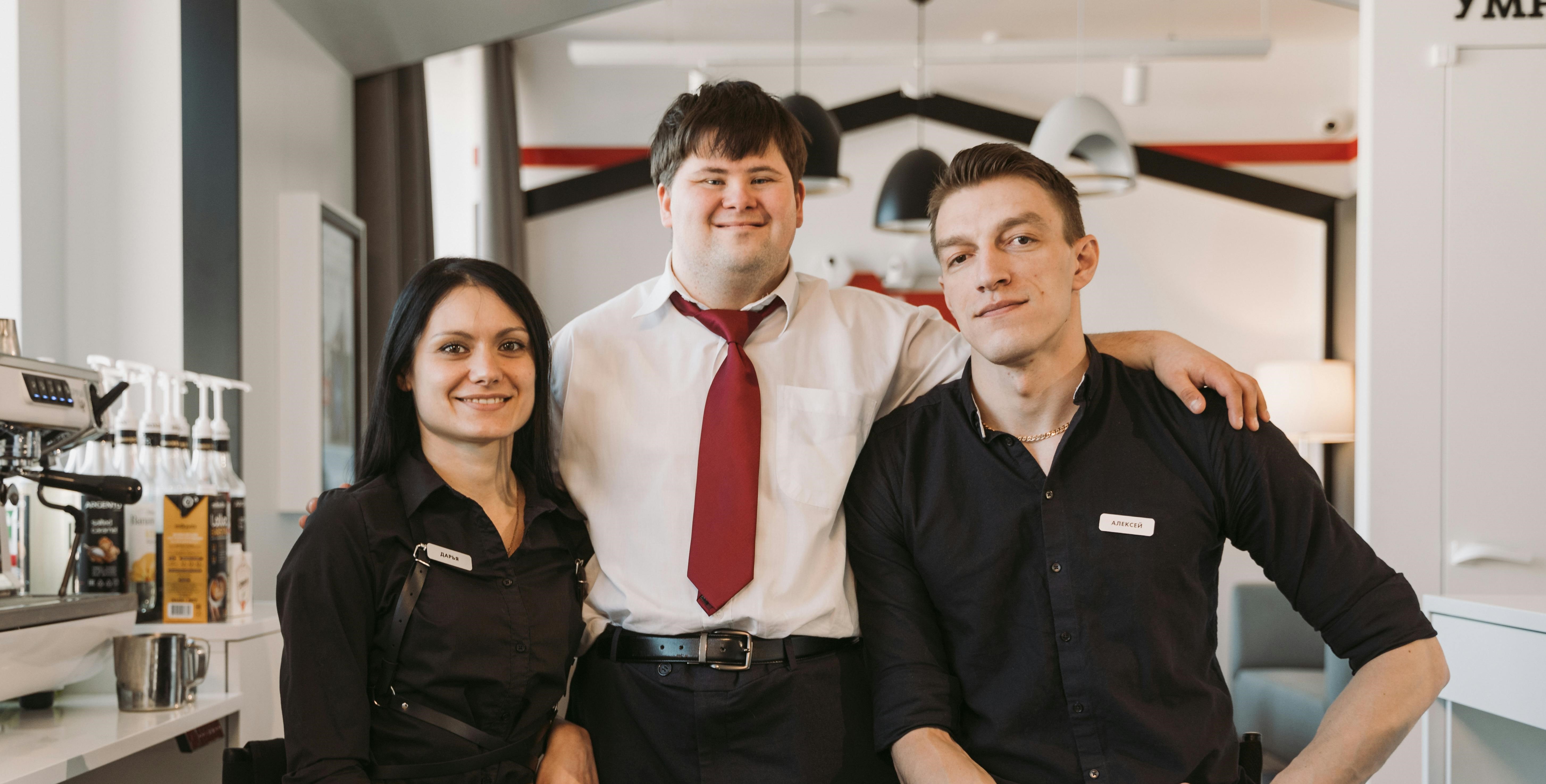 Ein selbstbewusster Manager steht stolz zwischen seinen Teammitgliedern | Quelle: Pexels