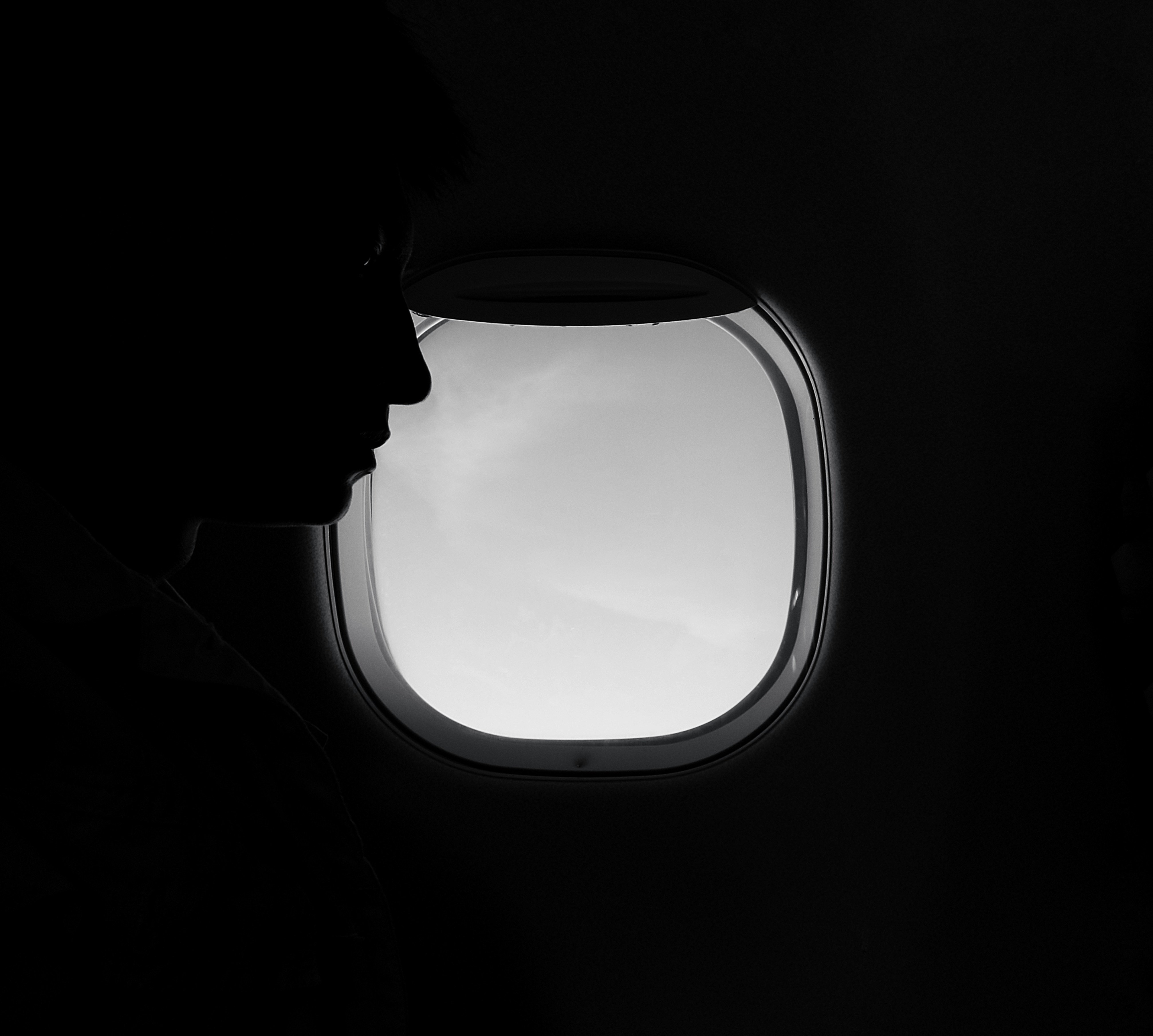 Eine Frau schaut auf den Sitz vor ihr in einem Flugzeug | Quelle: Unsplash