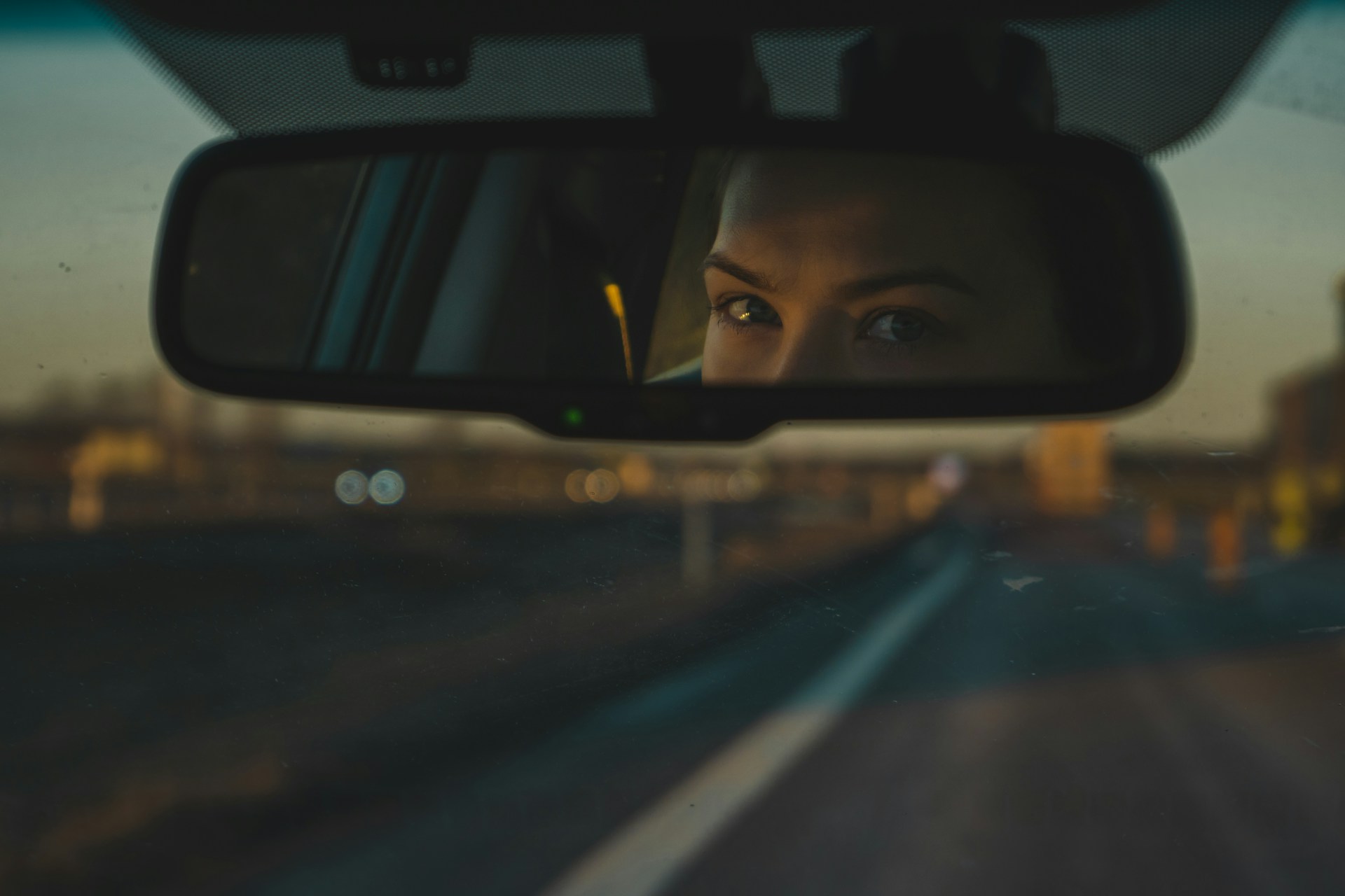 Eine Frau schaut in den Rückspiegel | Quelle: Unsplash