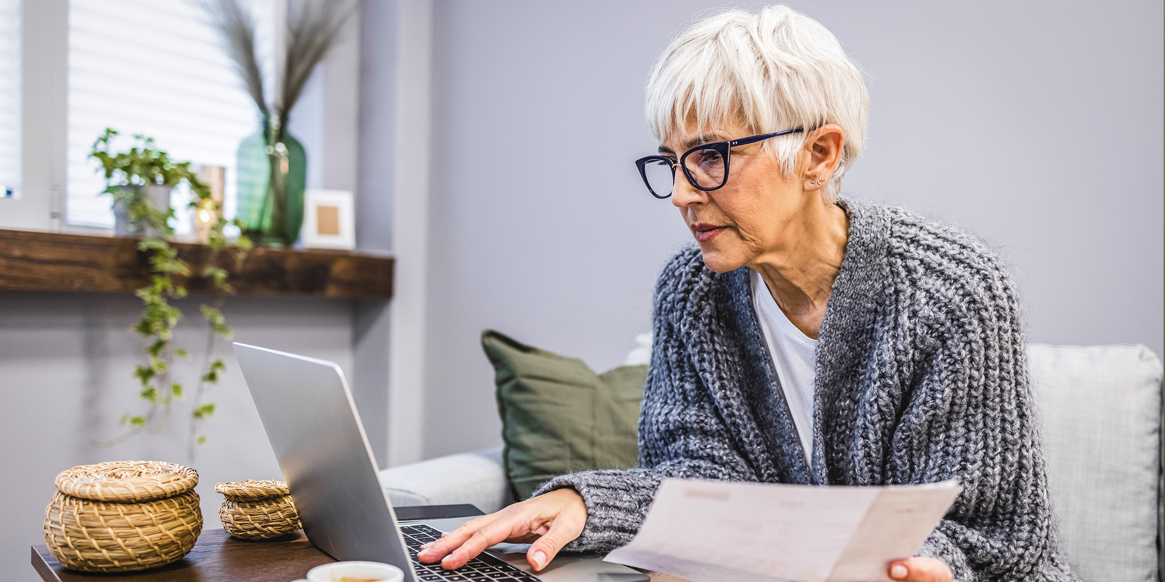 Eine ältere Frau arbeitet an einem Laptop | Quelle: Shutterstock