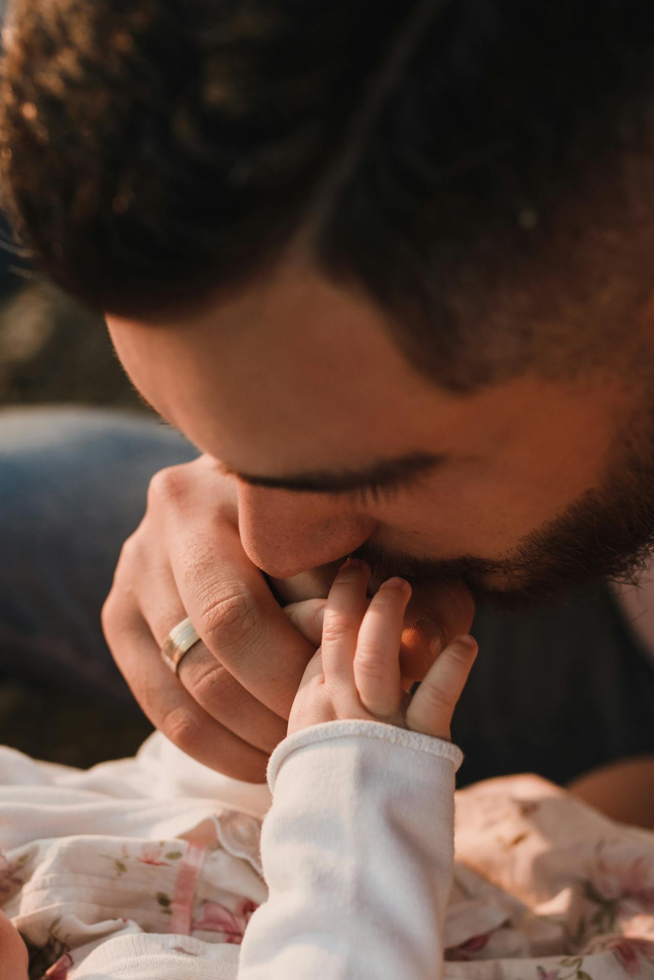 Ein Mann küsst sein Baby auf die Hand | Quelle: Pexels