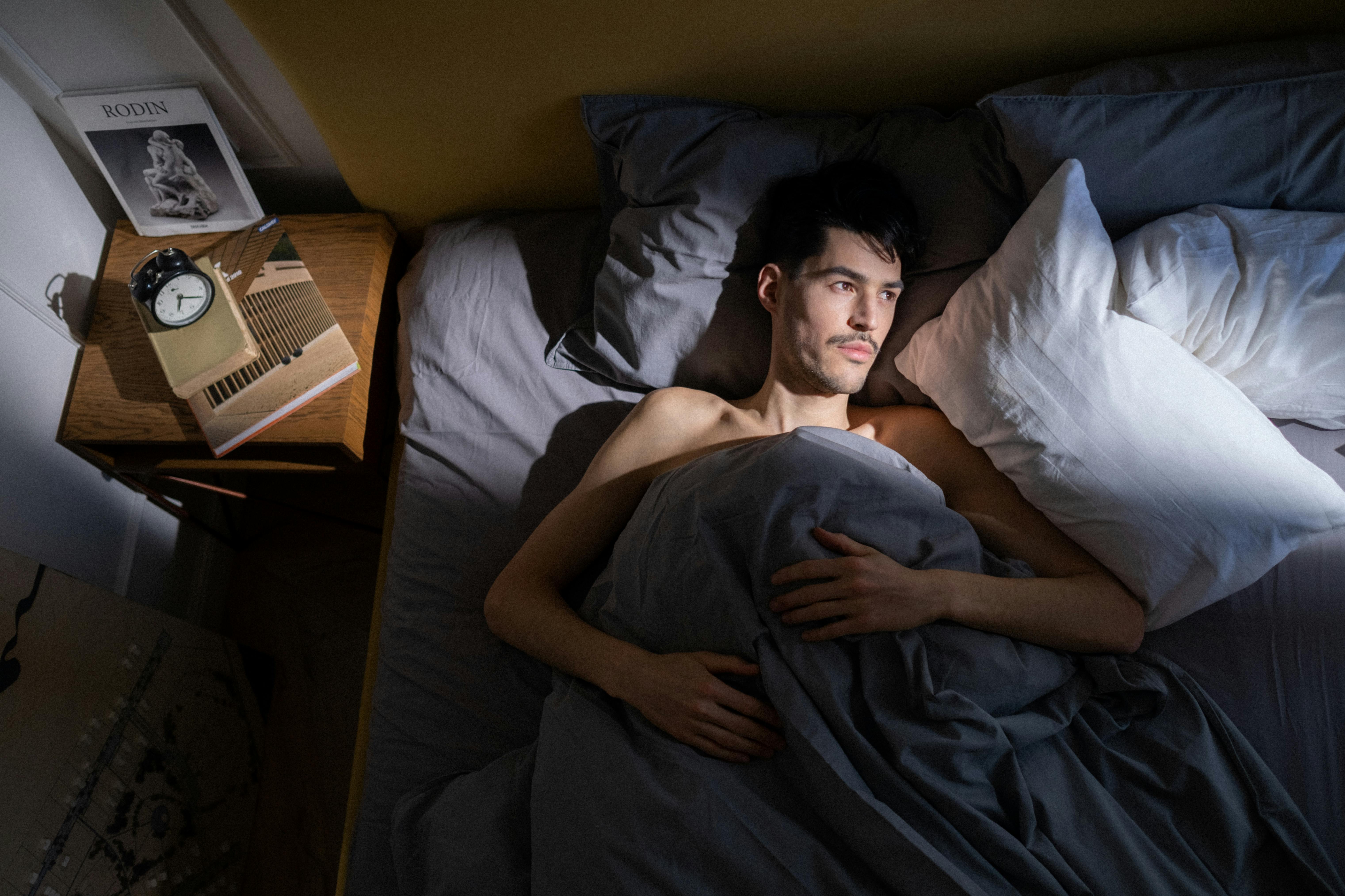 Mann liegt im Bett | Quelle: Pexels