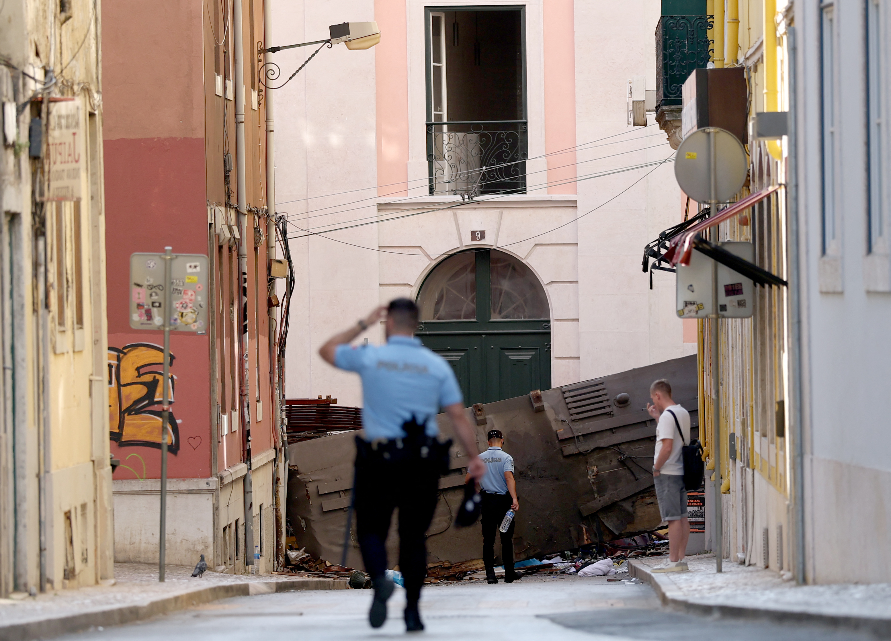 Polizisten gehen am Tag nach dem Unfall, bei dem 15 Menschen ums Leben kamen, auf das Dach der zerstörten Gloria-Standseilbahn in Lissabon, am 4. September 2025. | Quelle: Getty Images