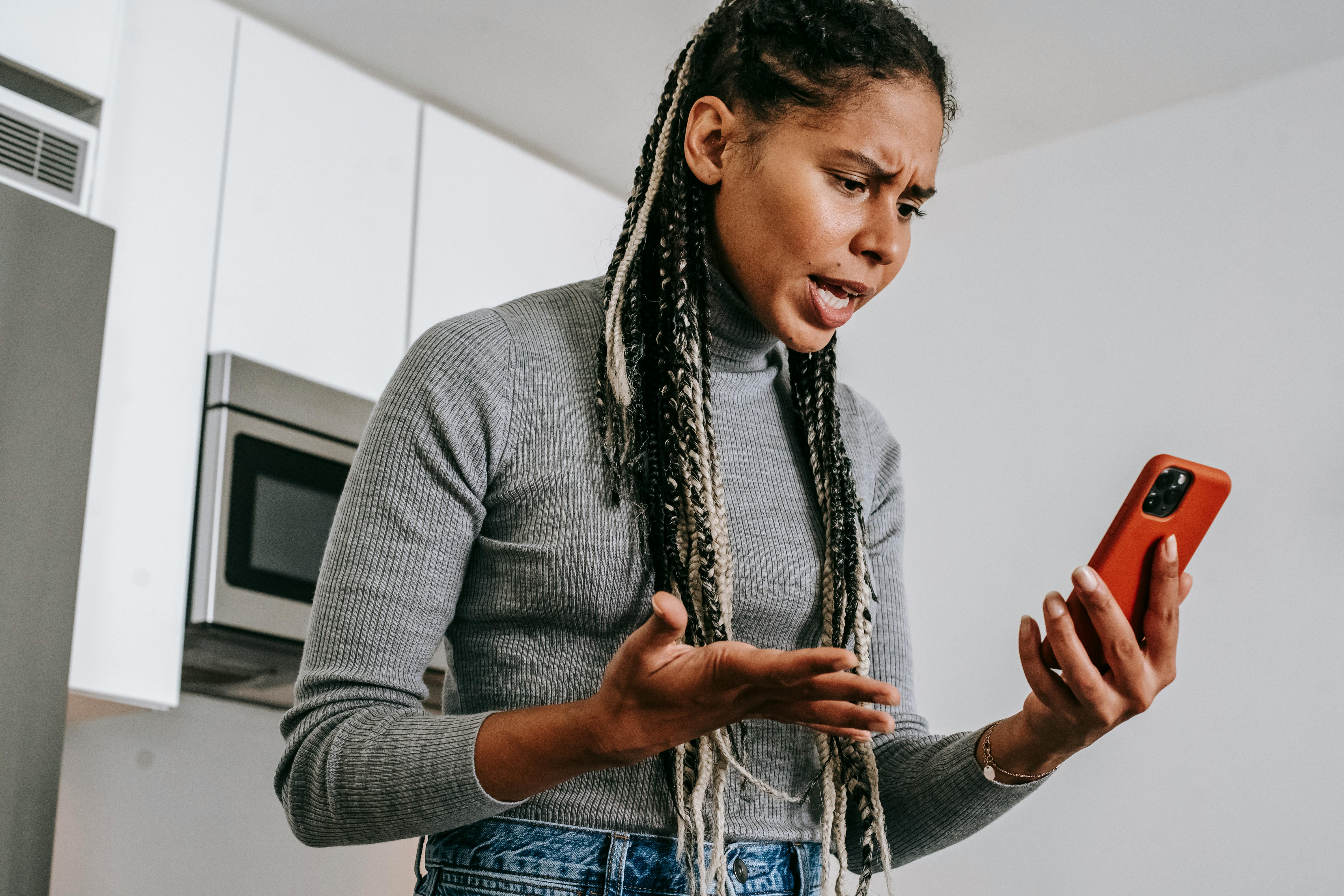 Eine Frau, die in ein Mobiltelefon schreit | Quelle: Pexels