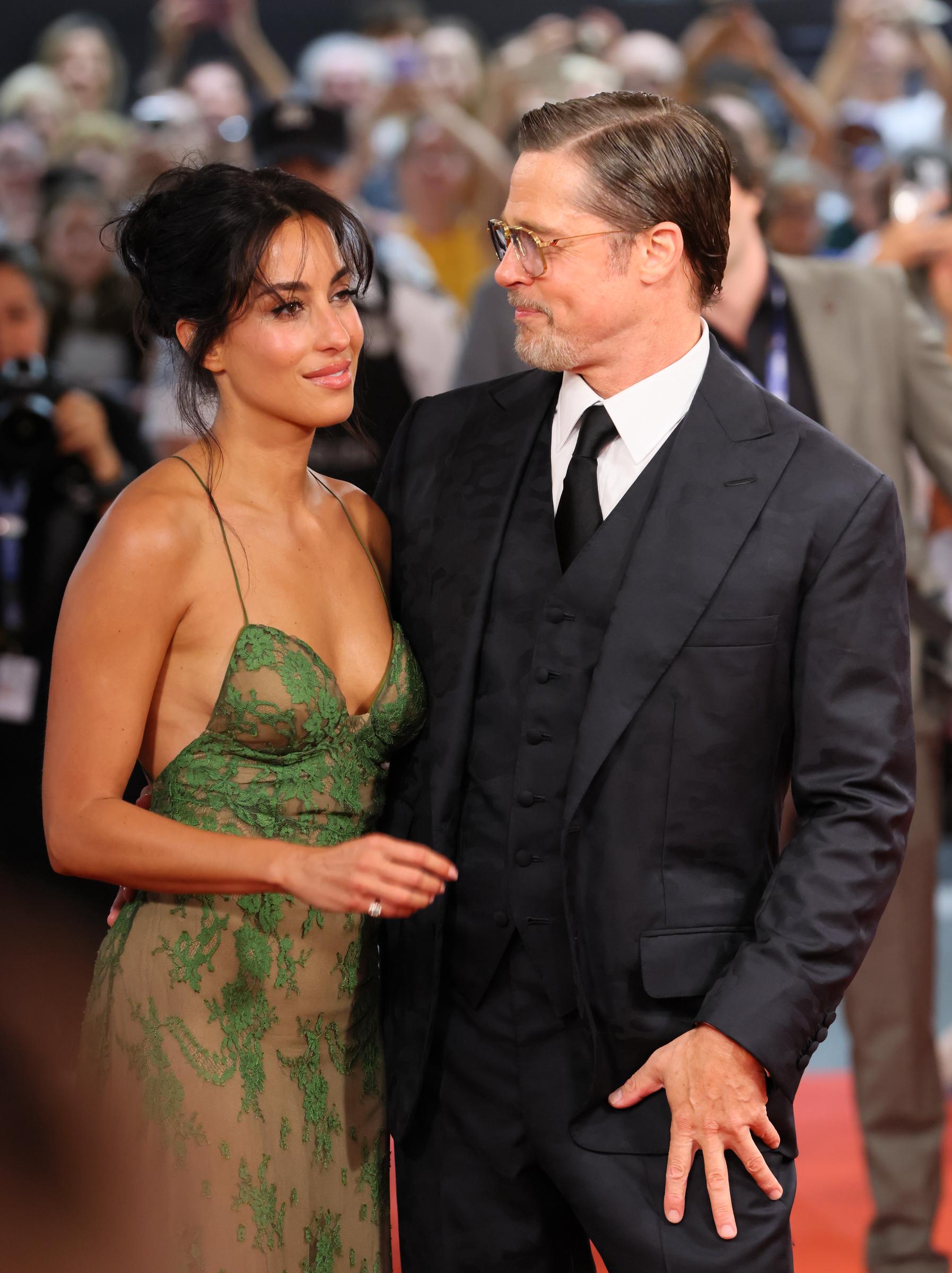 De Ramon blickte in die Kameras, während Pitt in einer weiteren Nahaufnahme aus der Filmvorführung zu ihr herüberschaute. Die Einstellung zeigte deutlich den Kontrast zwischen ihren Outfits: ihre lockere Hochsteckfrisur und die grüne Spitze standen im Gegensatz zu seinem nach hinten gegelten Haar und seinem schwarzen Anzug.