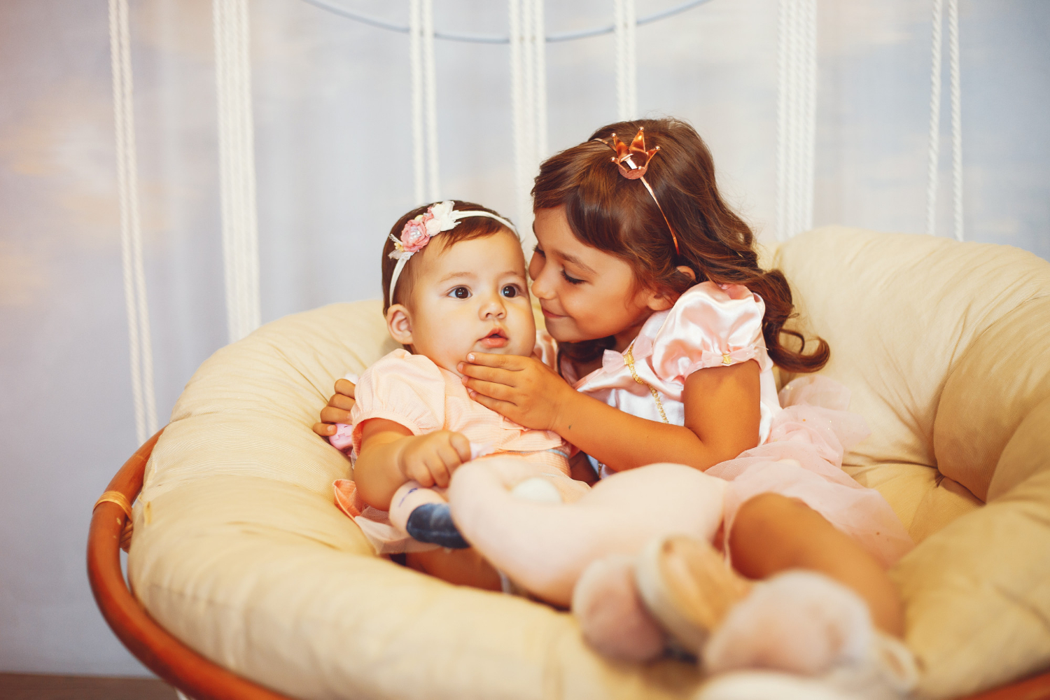 Ein kleines Mädchen und ein Baby sitzen auf einem Stuhl | Quelle: Freepik