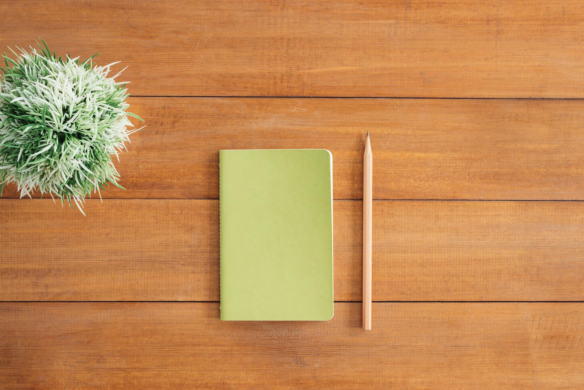 Ein Notizbuch und ein Bleistift auf einem Tisch | Quelle: Pexels