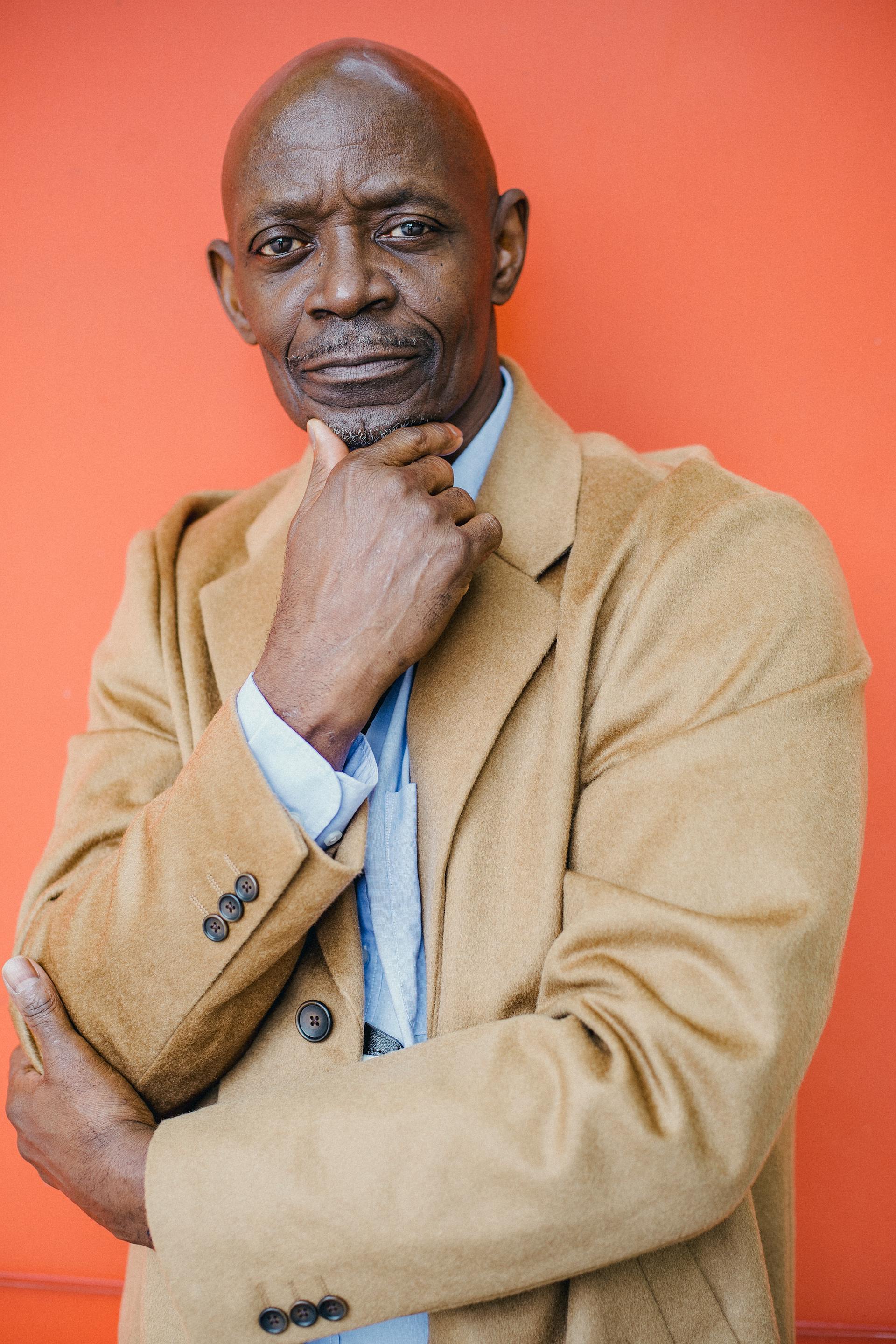 Ein schwarzer Mann in einem Mantel, der jemanden ansieht | Quelle: Pexels