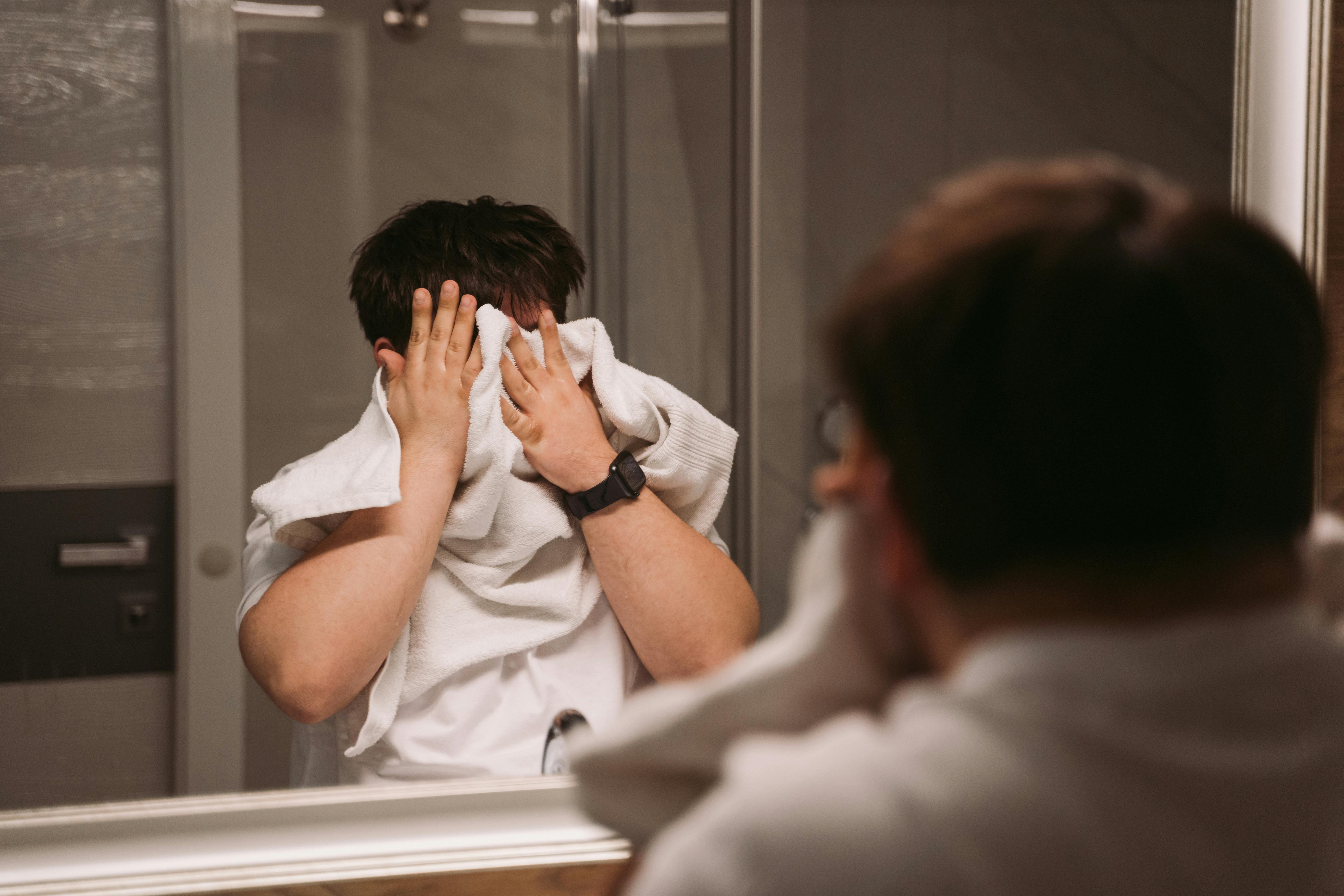 Ein Mann, der sich mit einem Handtuch das Gesicht abwischt | Quelle: Pexels