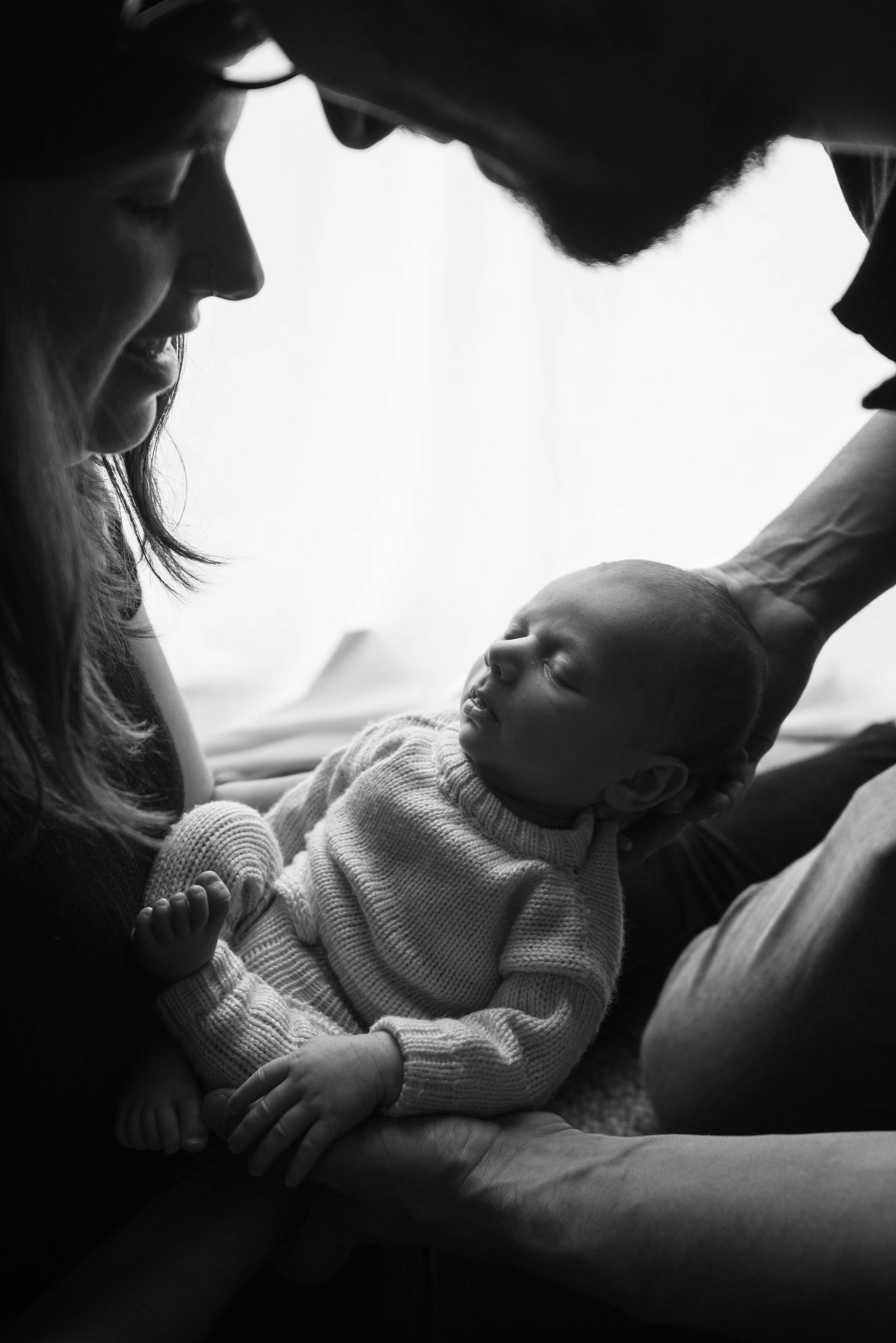 Ein Graustufenfoto von einem Paar, das ein neugeborenes Baby im Arm hält | Quelle: Pexels
