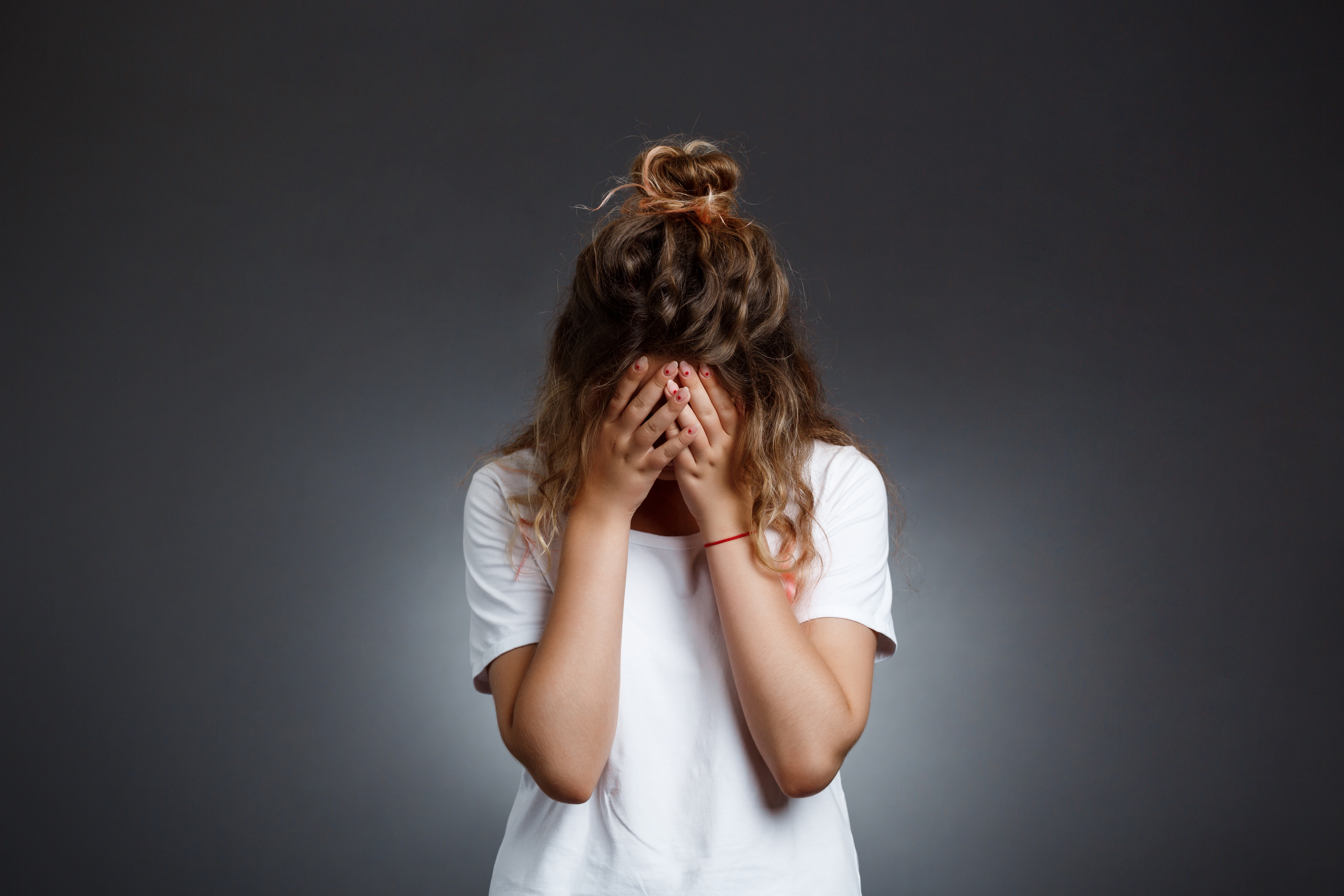 Zdenerwowana kobieta z głową w dłoniach | Źródło: Shutterstock