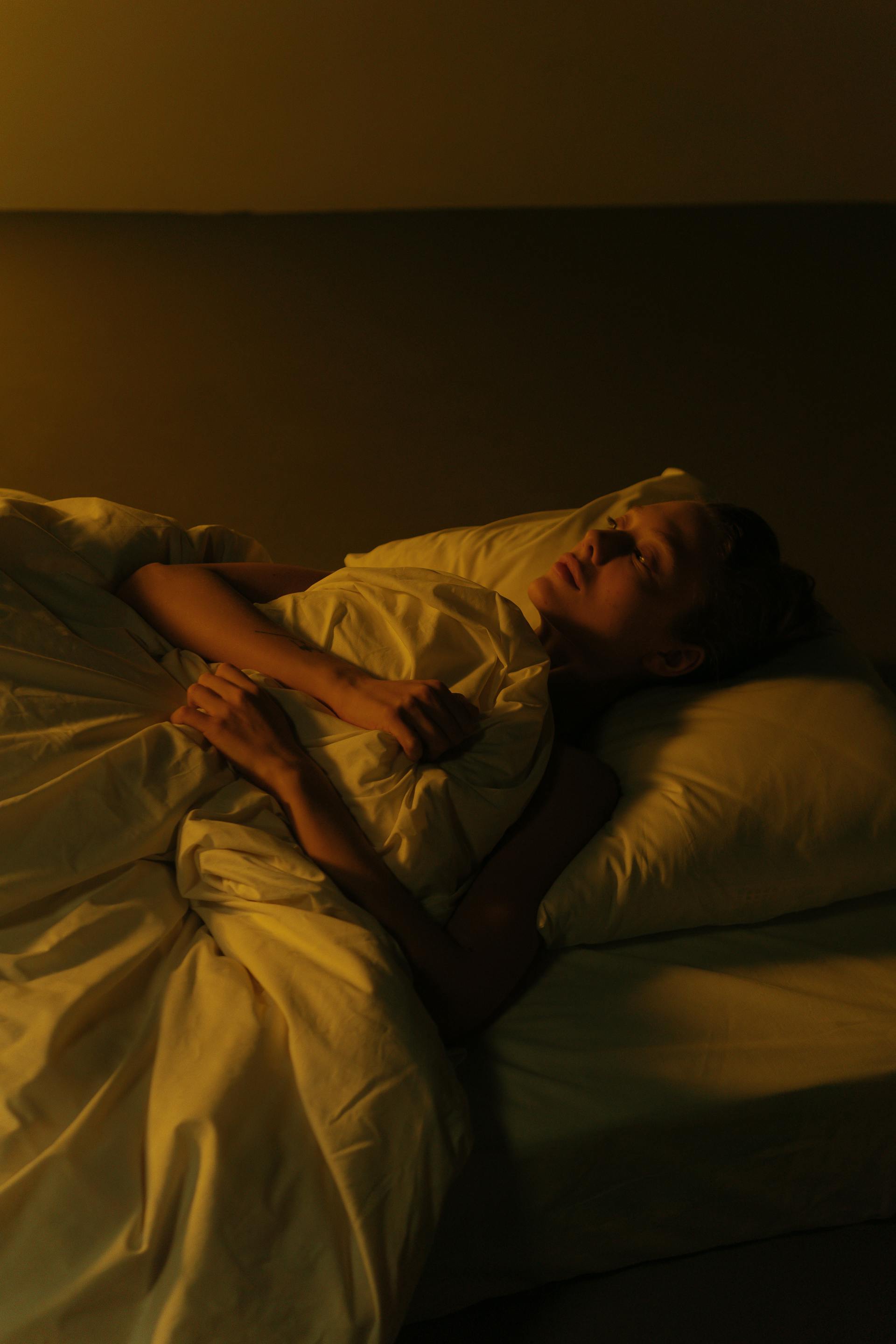 Eine Frau, die wach im Bett liegt | Quelle: Pexels