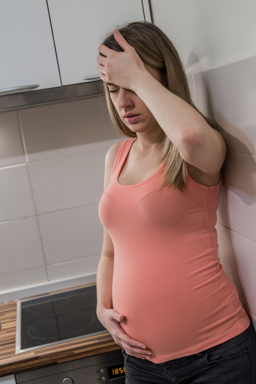 Eine gestresste schwangere Frau steht in der Küche | Quelle: Freepik
