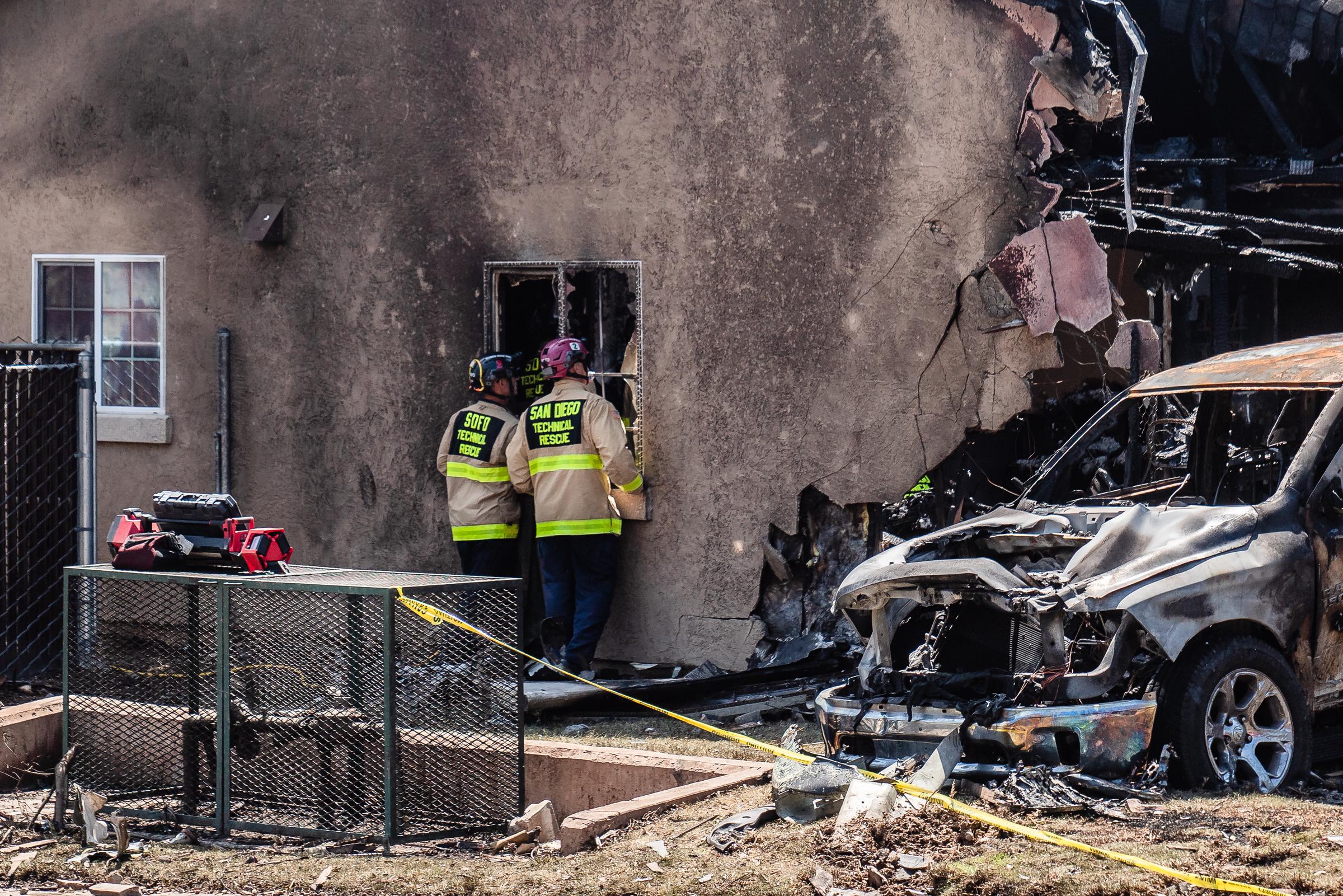 Einsatzkräfte der Feuerwehr von San Diego durchsuchen ein beschädigtes Haus in San Diego, Kalifornien, nachdem ein Kleinflugzeug am 22. Mai 2025 in die Nachbarschaft gestürzt ist | Quelle: Getty Images