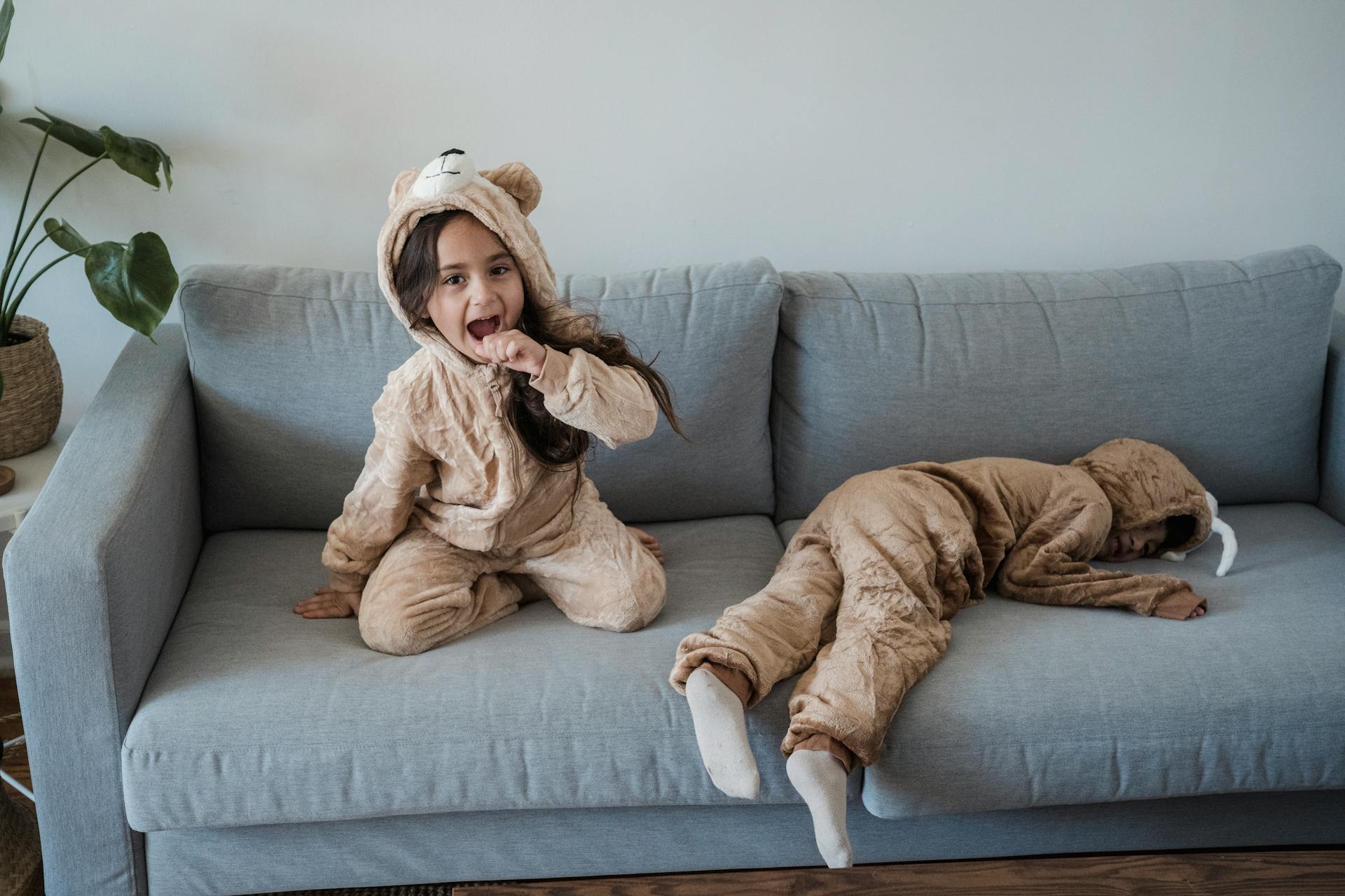 Zwei Kinder sitzen auf einer Couch | Quelle: Pexels