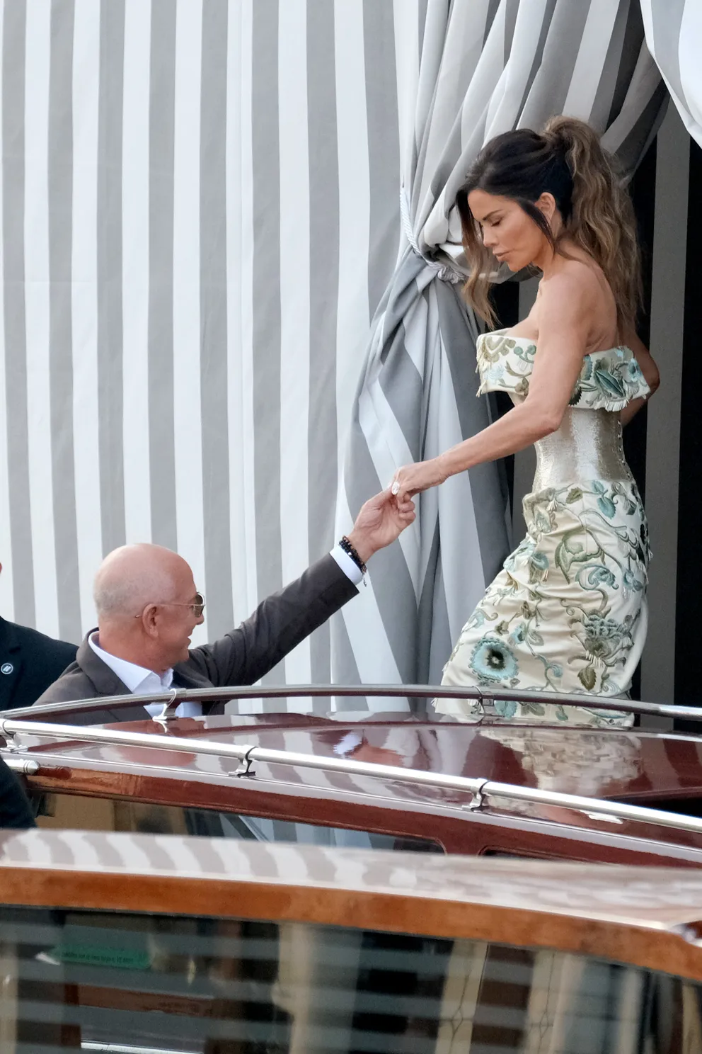 Jeff Bezos hilft seiner Verlobten Lauren Sánchez, die ein Couture-Kleid von Schiaparelli trägt, beim Einsteigen in ein Wassertaxi in Venedig am 26. Juni 2025. | Quelle: Getty Images