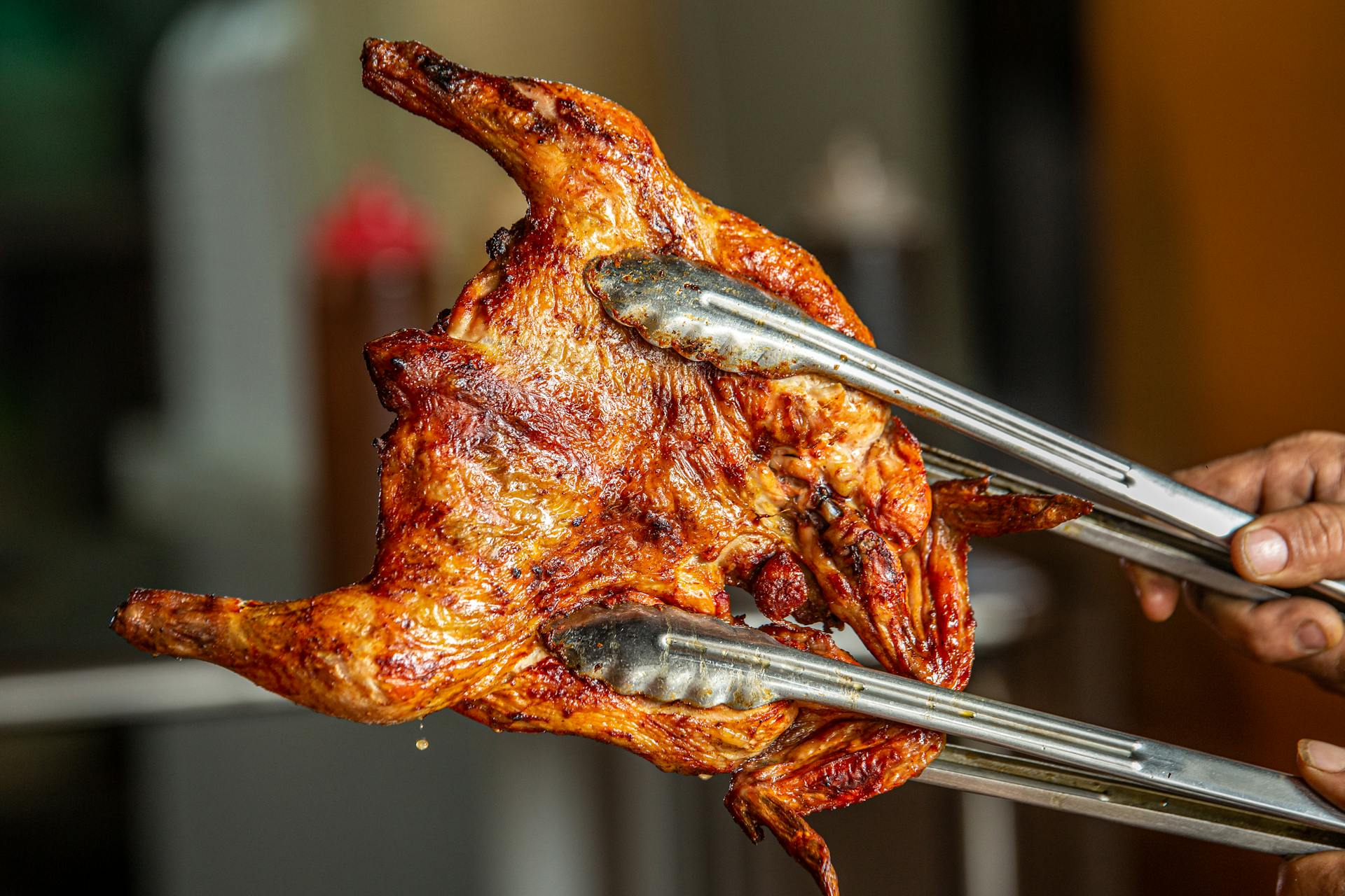 Eine Person hält ein gebratenes Huhn | Quelle: Pexels