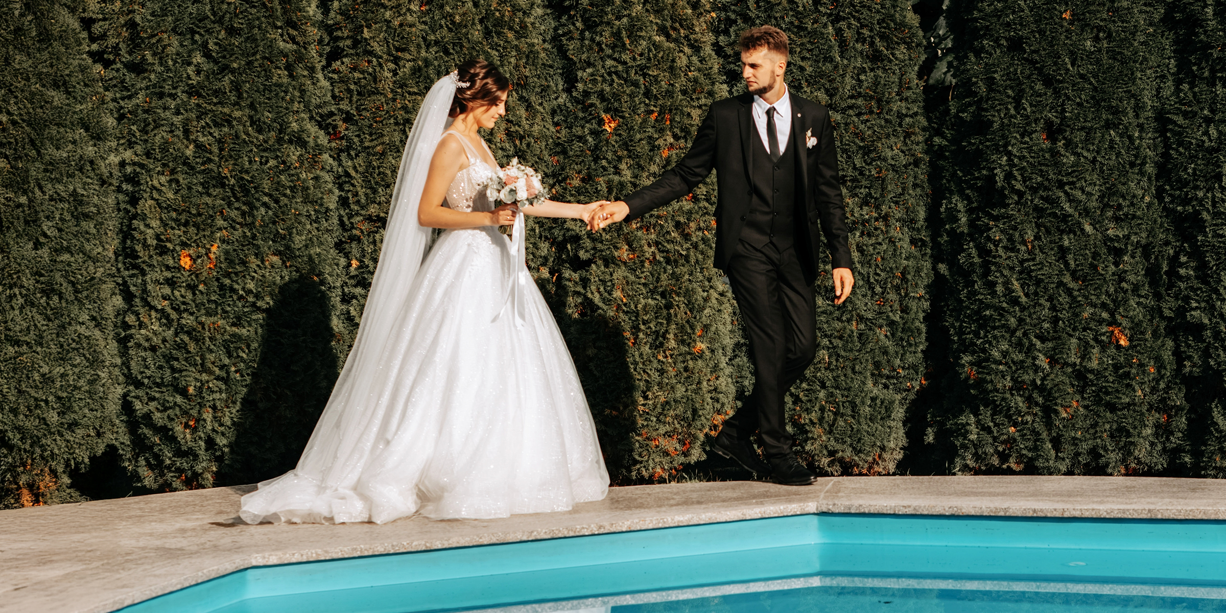 Ein Brautpaar, das an einem Pool steht | Quelle: Shutterstock