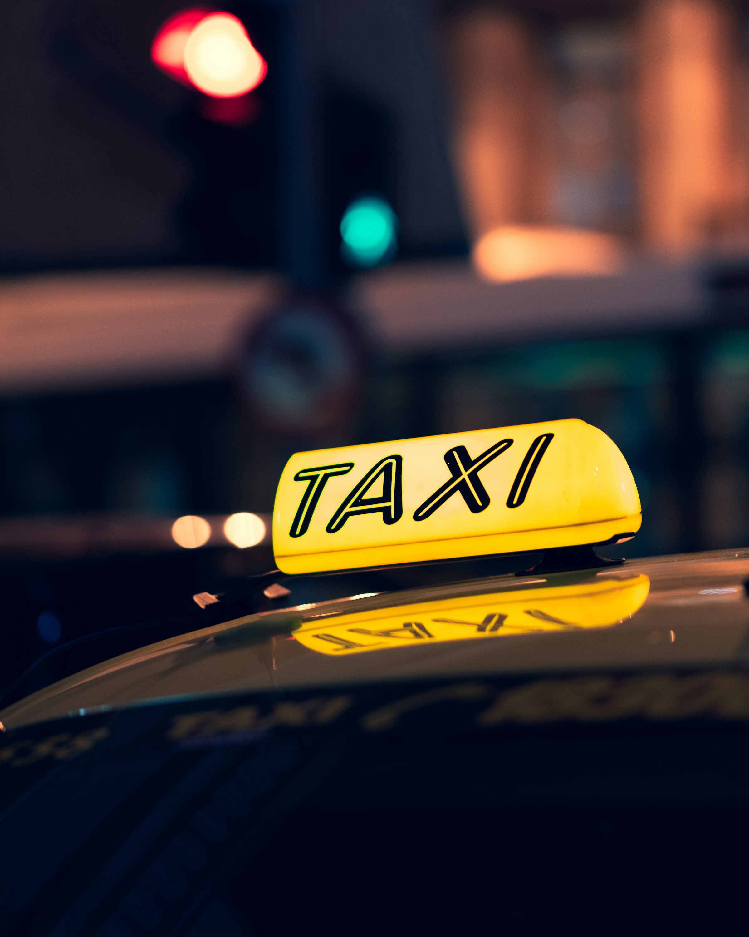 Nahaufnahme eines Taxis auf der Straße in der Nacht | Quelle: Unsplash