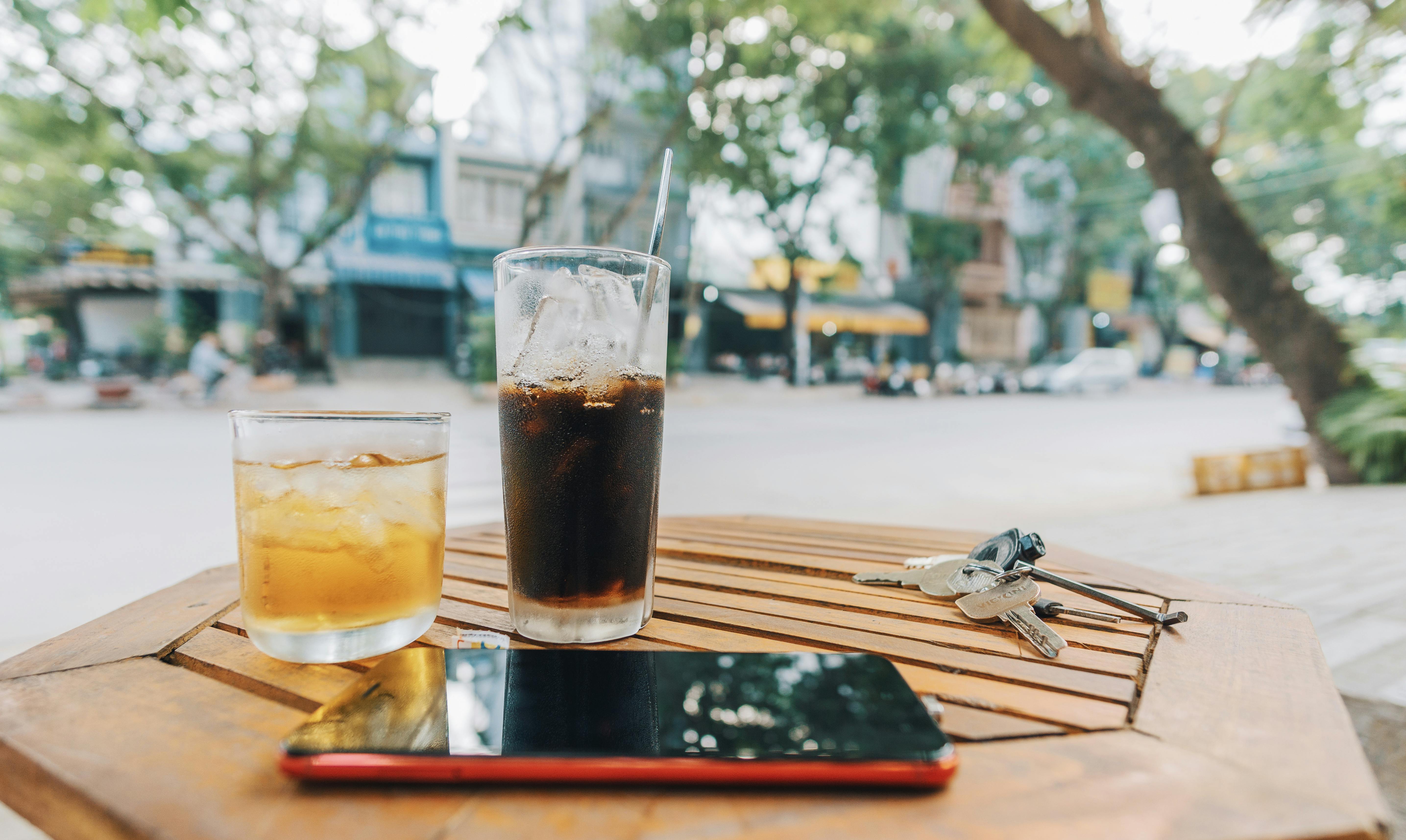 Getränke, ein Telefon und Schlüssel auf einem Tisch | Quelle: Pexels
