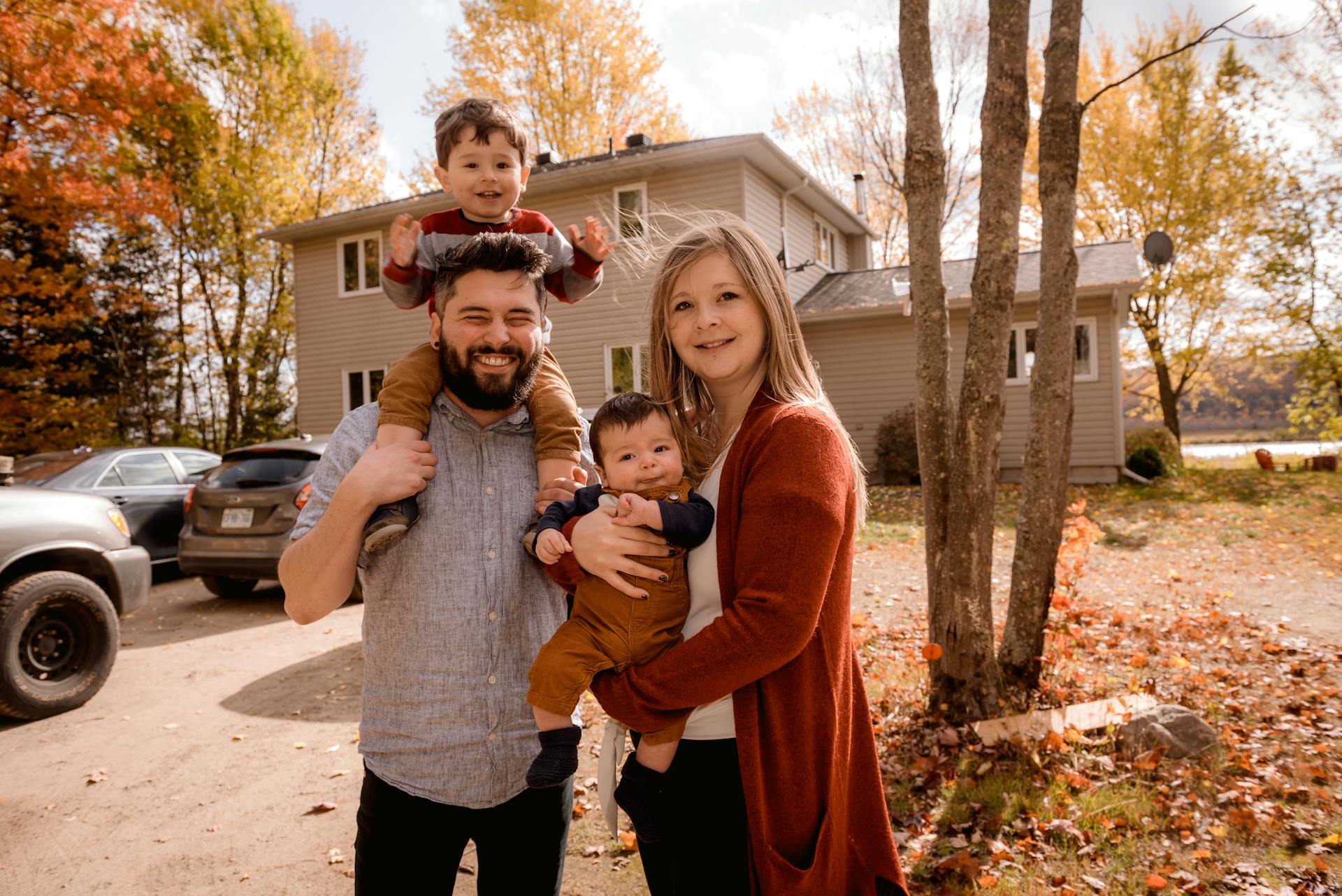 Eine glückliche Familie steht vor einem Haus | Quelle: Pexels