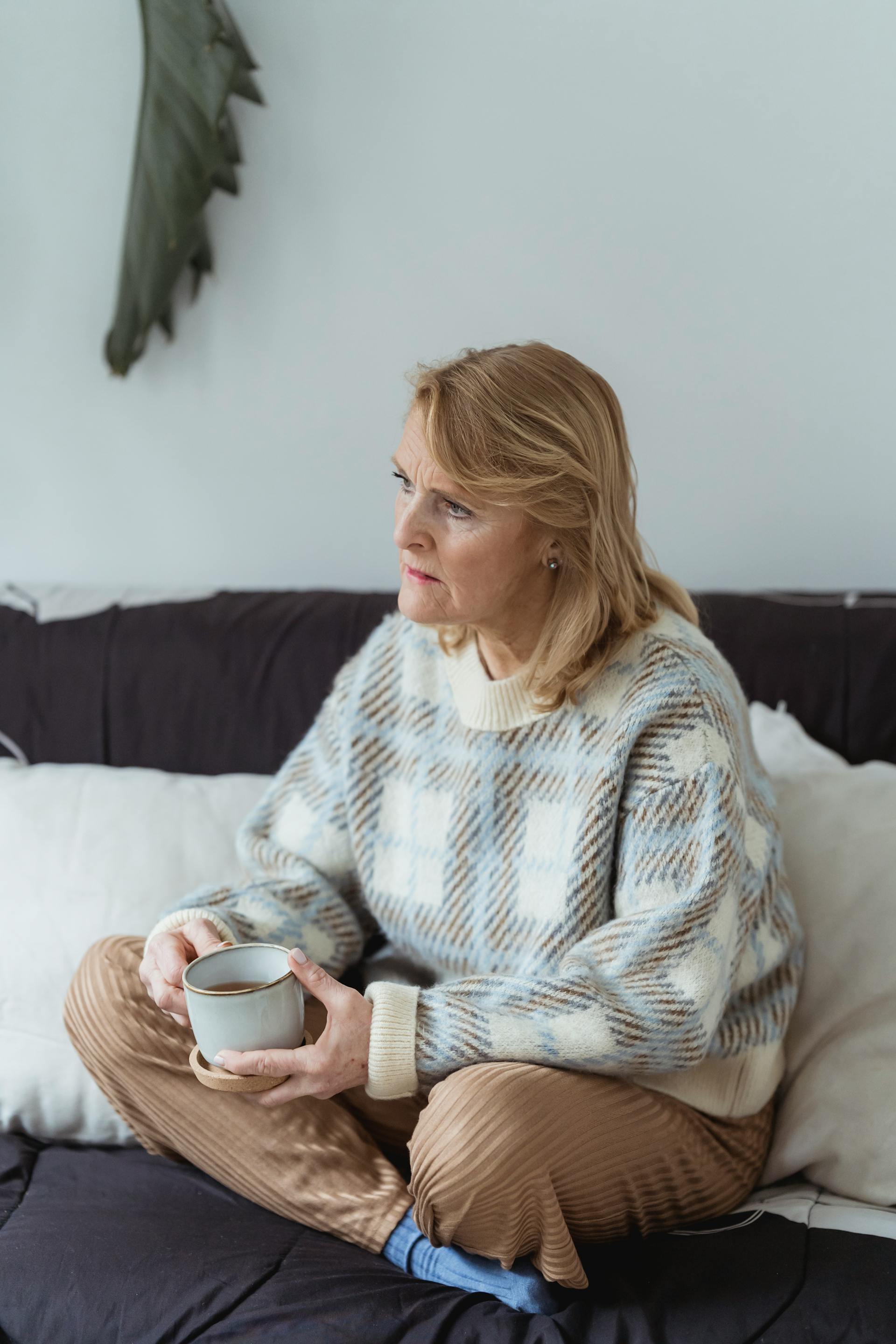 Eine Frau mittleren Alters, die einen Becher hält und jemanden anschaut | Quelle: Pexels