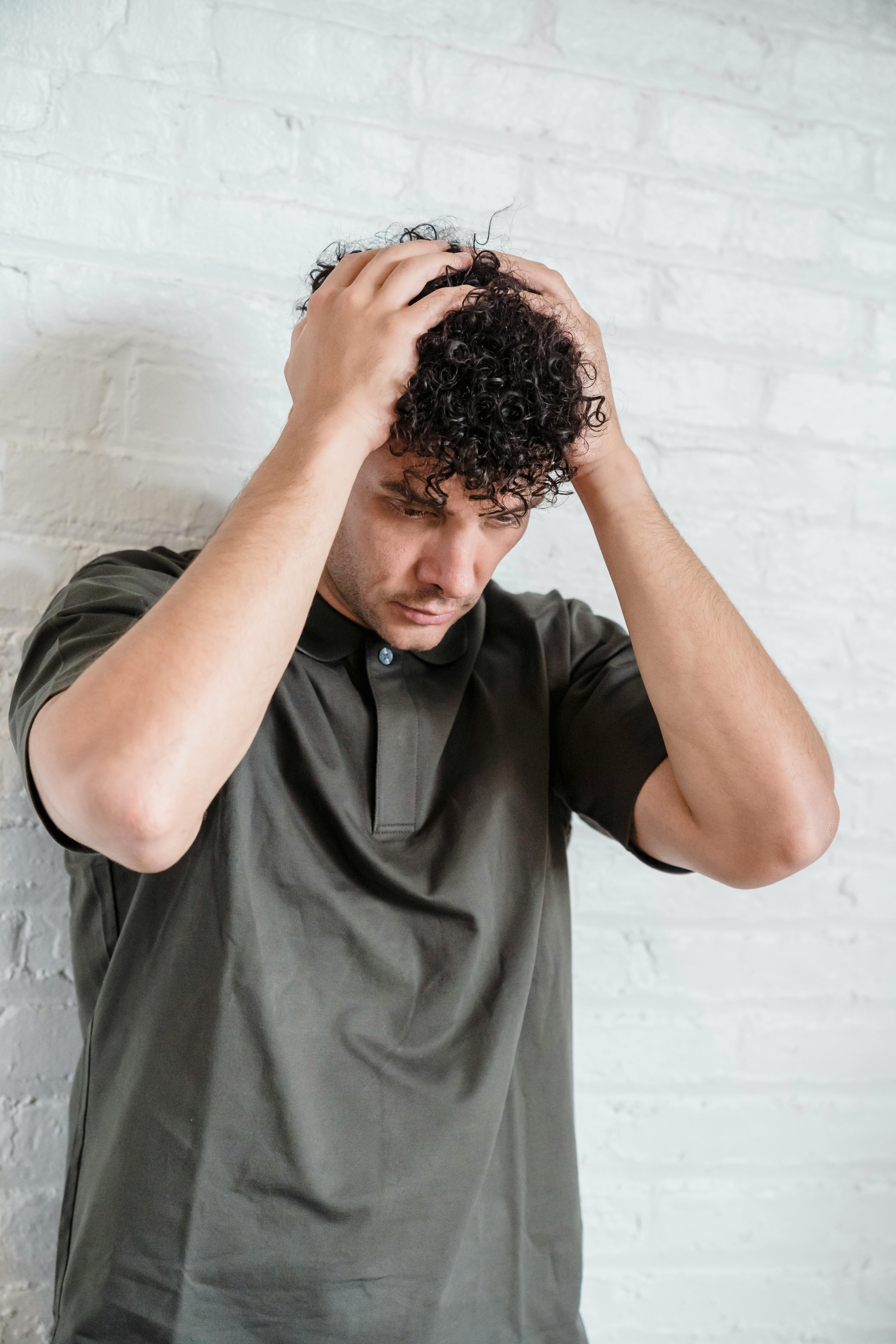 Ein Mann, der seinen Kopf hält | Quelle: Pexels