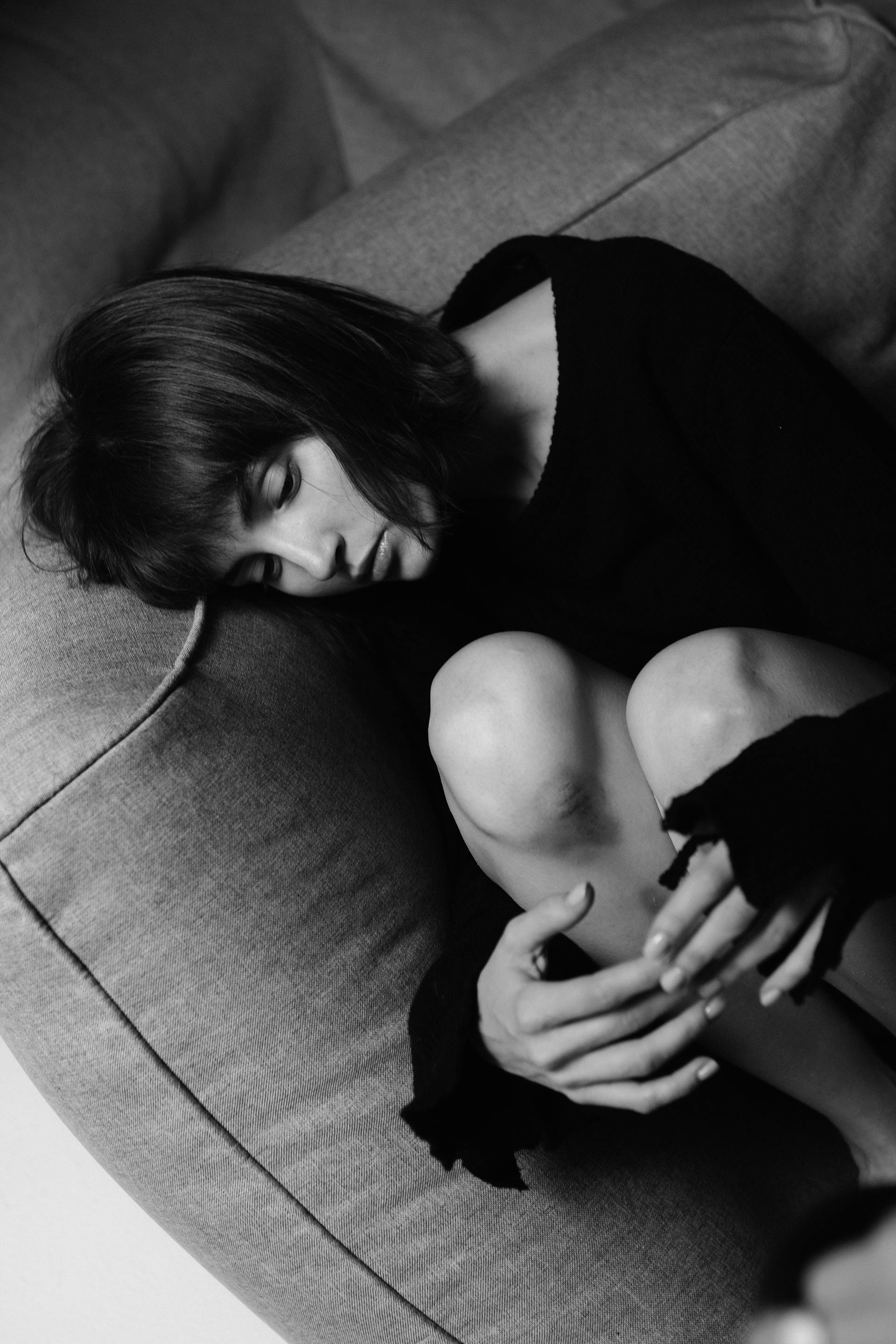Graustufenfoto einer Frau, die auf der Couch liegt | Quelle: Pexels