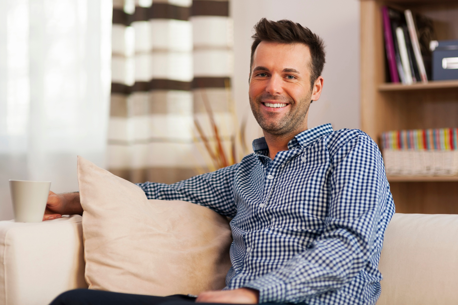 Ein Mann sitzt auf der Couch und lächelt | Quelle: Freepik