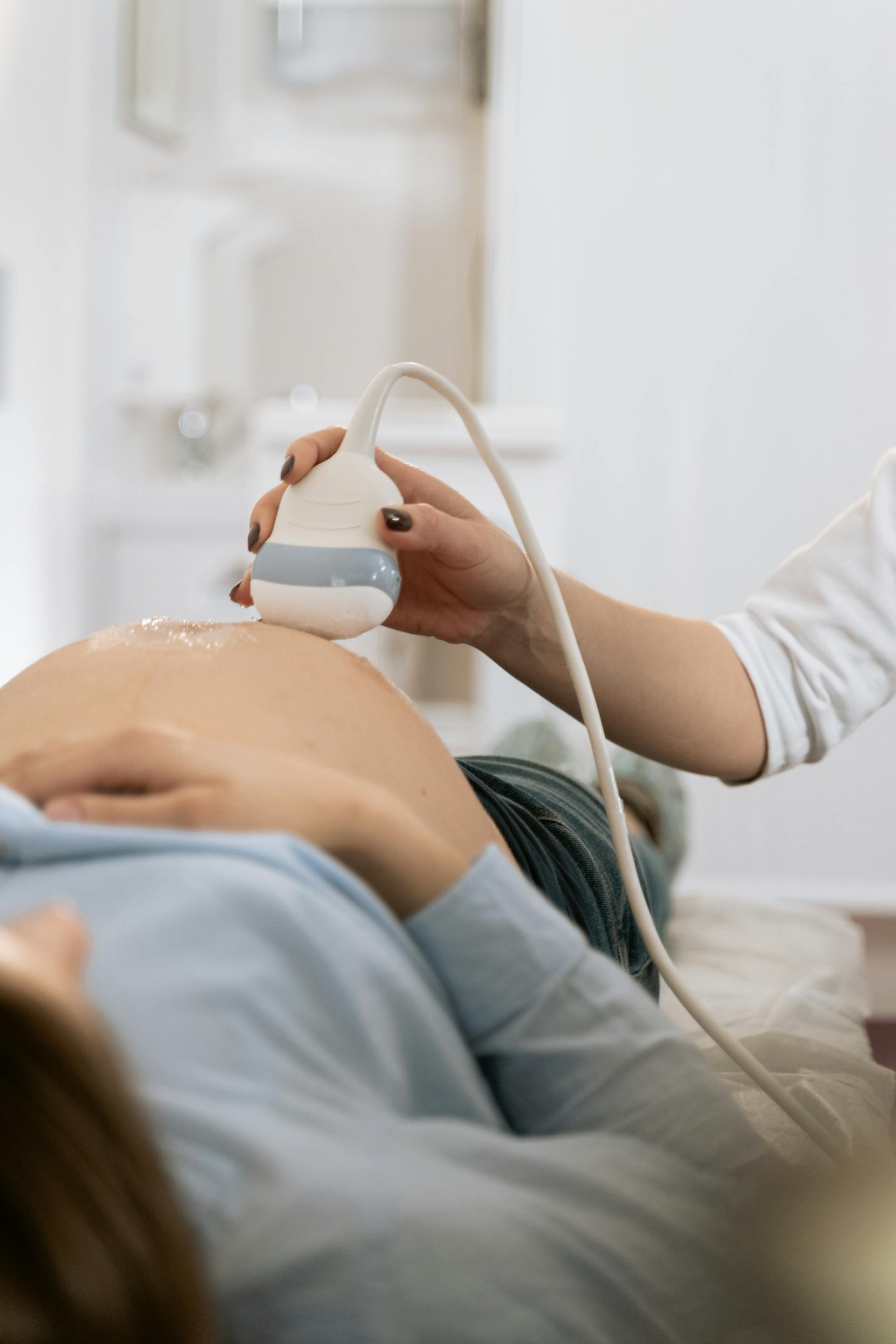 Eine schwangere Frau, die sich hinlegt und eine Ultraschalluntersuchung durchführen lässt | Quelle: Pexels